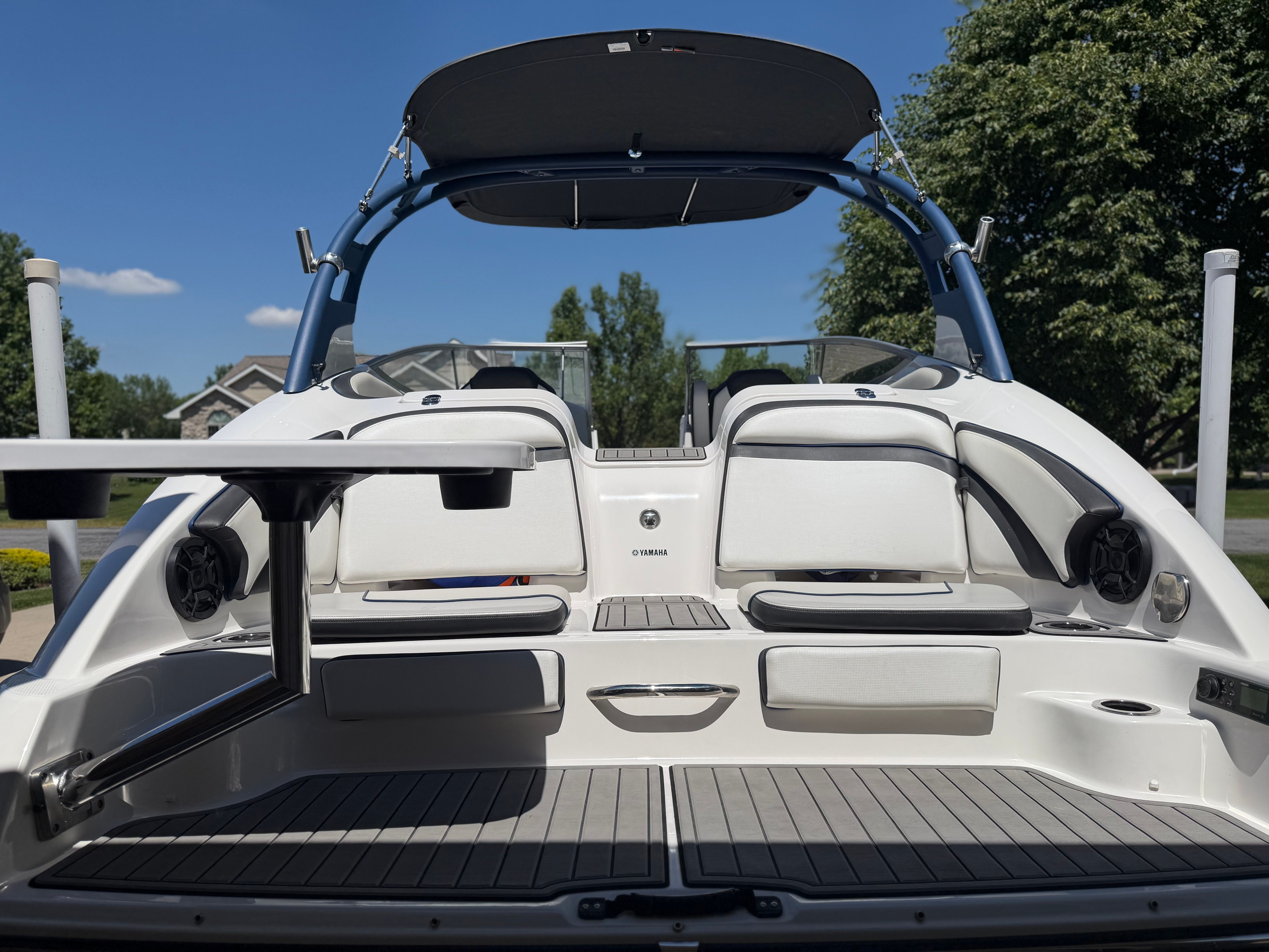 The image shows the stern of a 2018 Yamaha 242 Limited S boat with seating and a table.