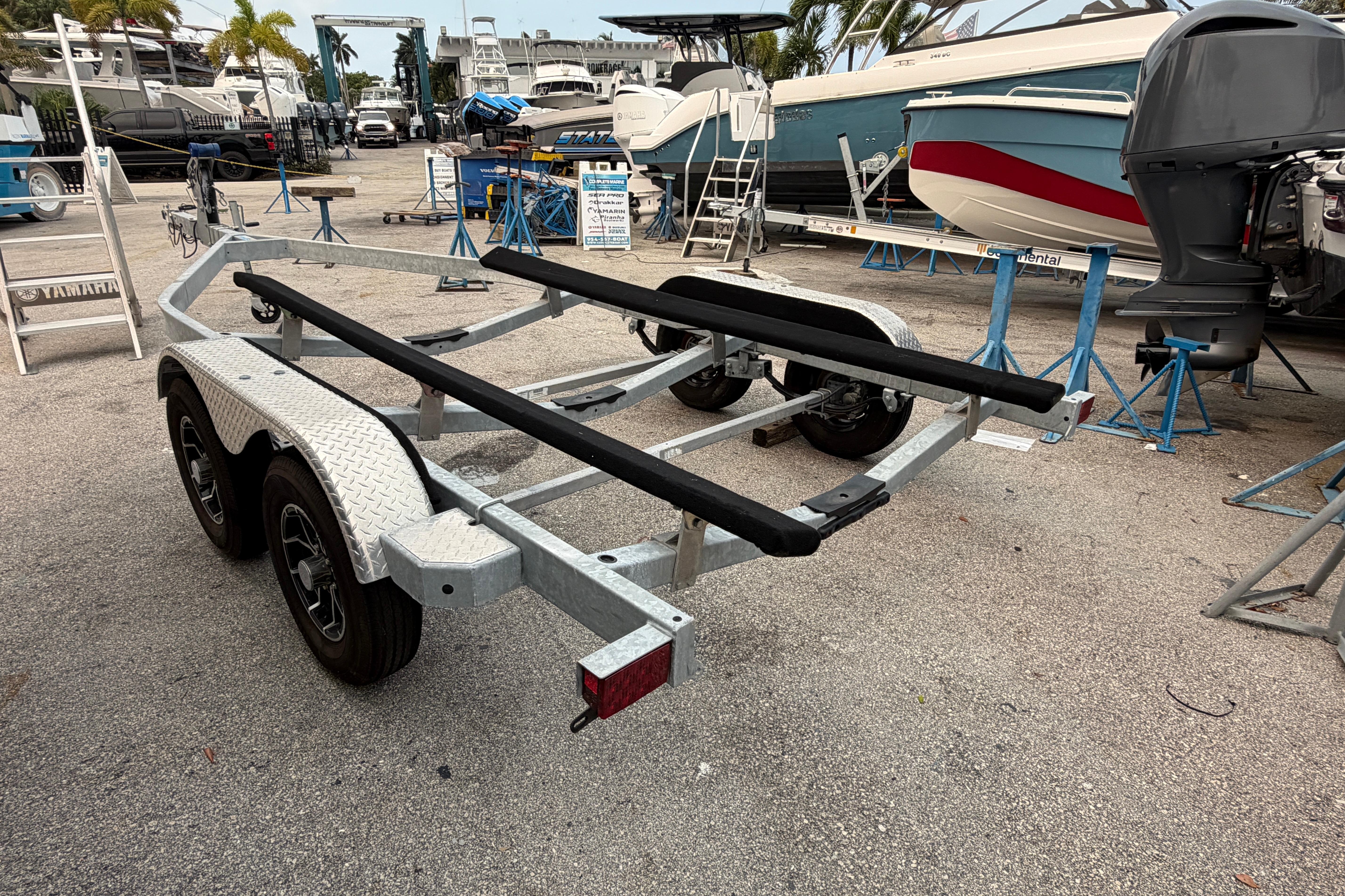 2024 SRT5000 boat trailer in a marina, surrounded by boats and equipment.