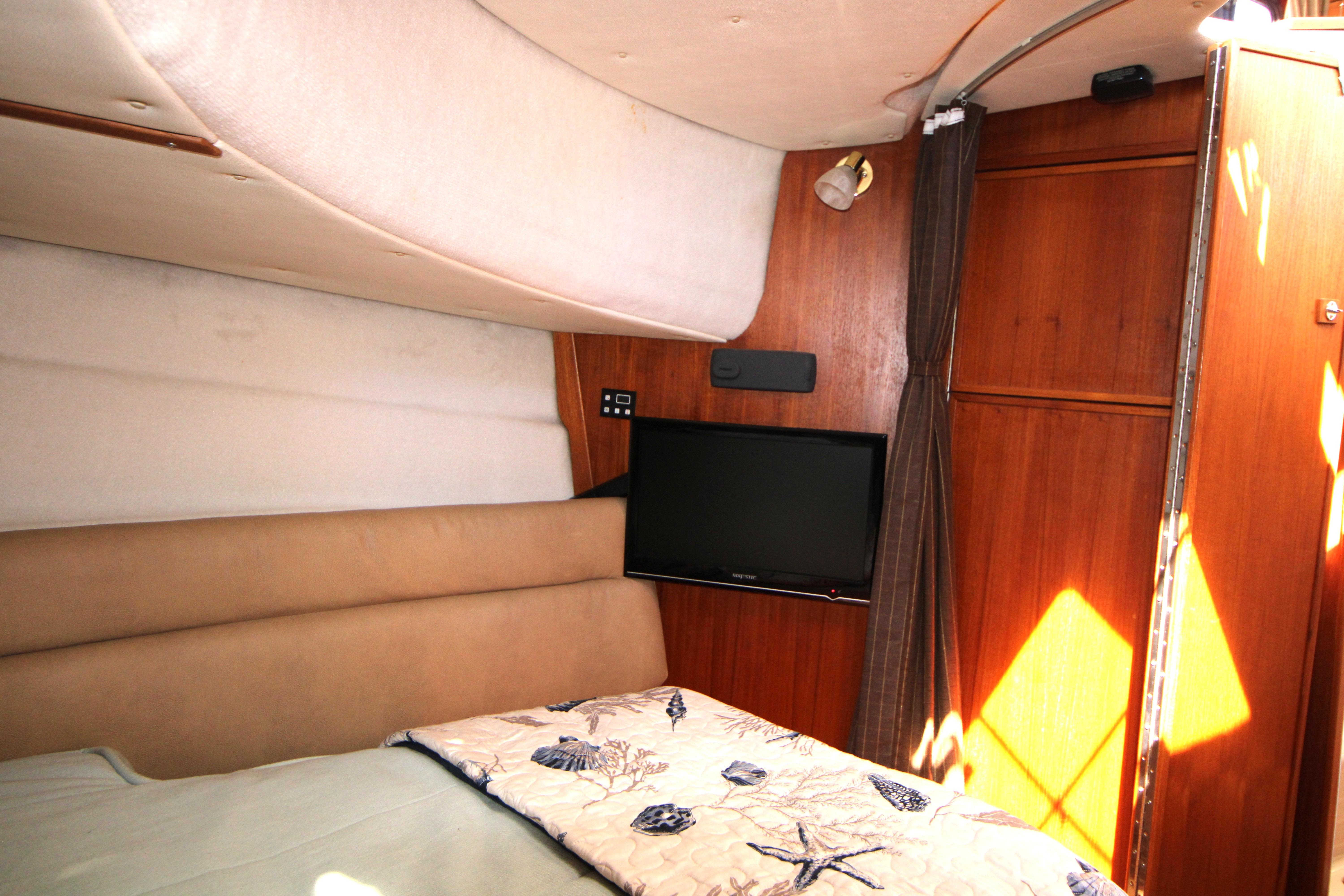 Interior cabin of 2013 Ranger Tugs R-31 CB with TV and cozy bedding.