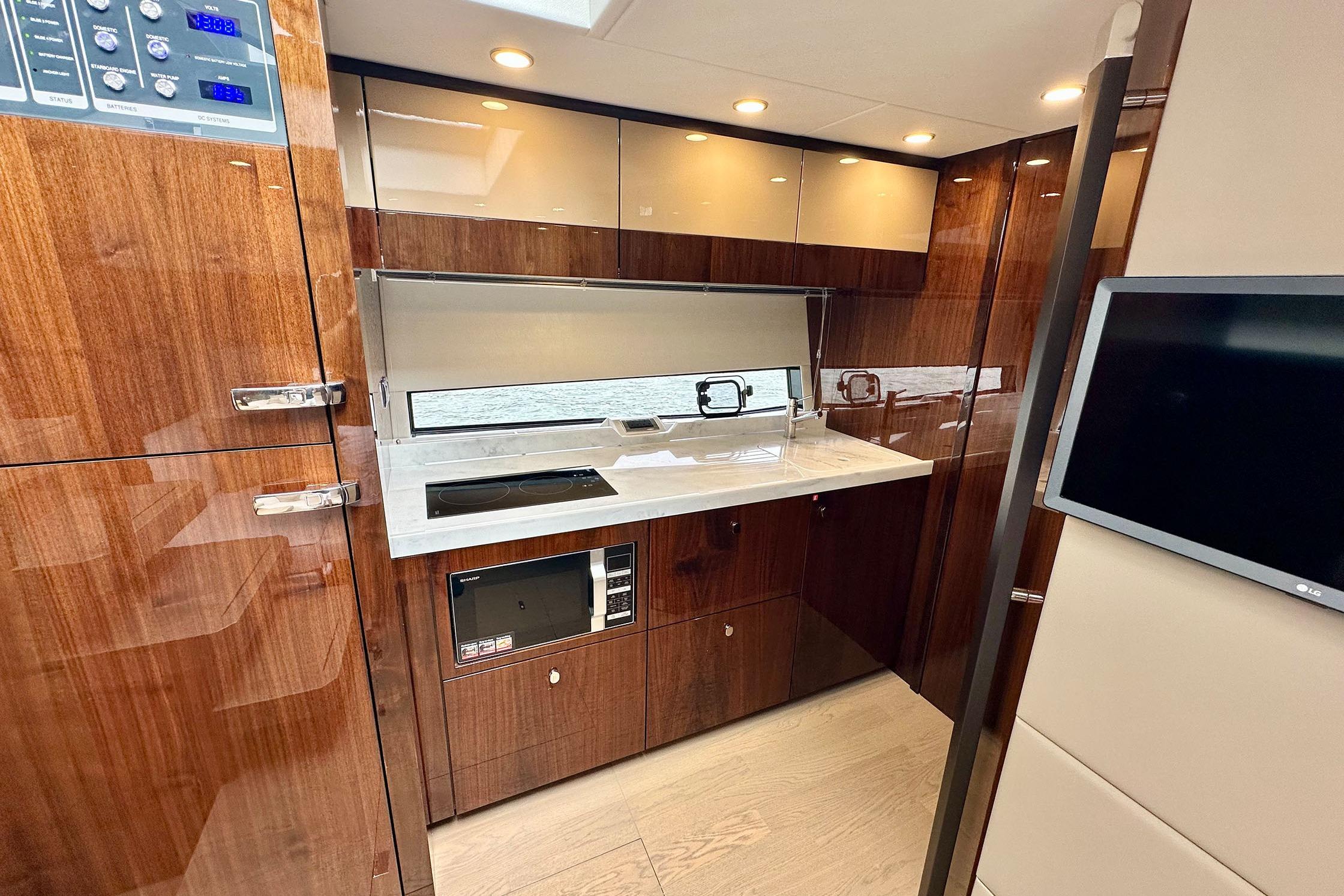 Luxurious 2022 Fairline Targa 50 GT yacht interior with modern kitchen and sleek wood finishes.