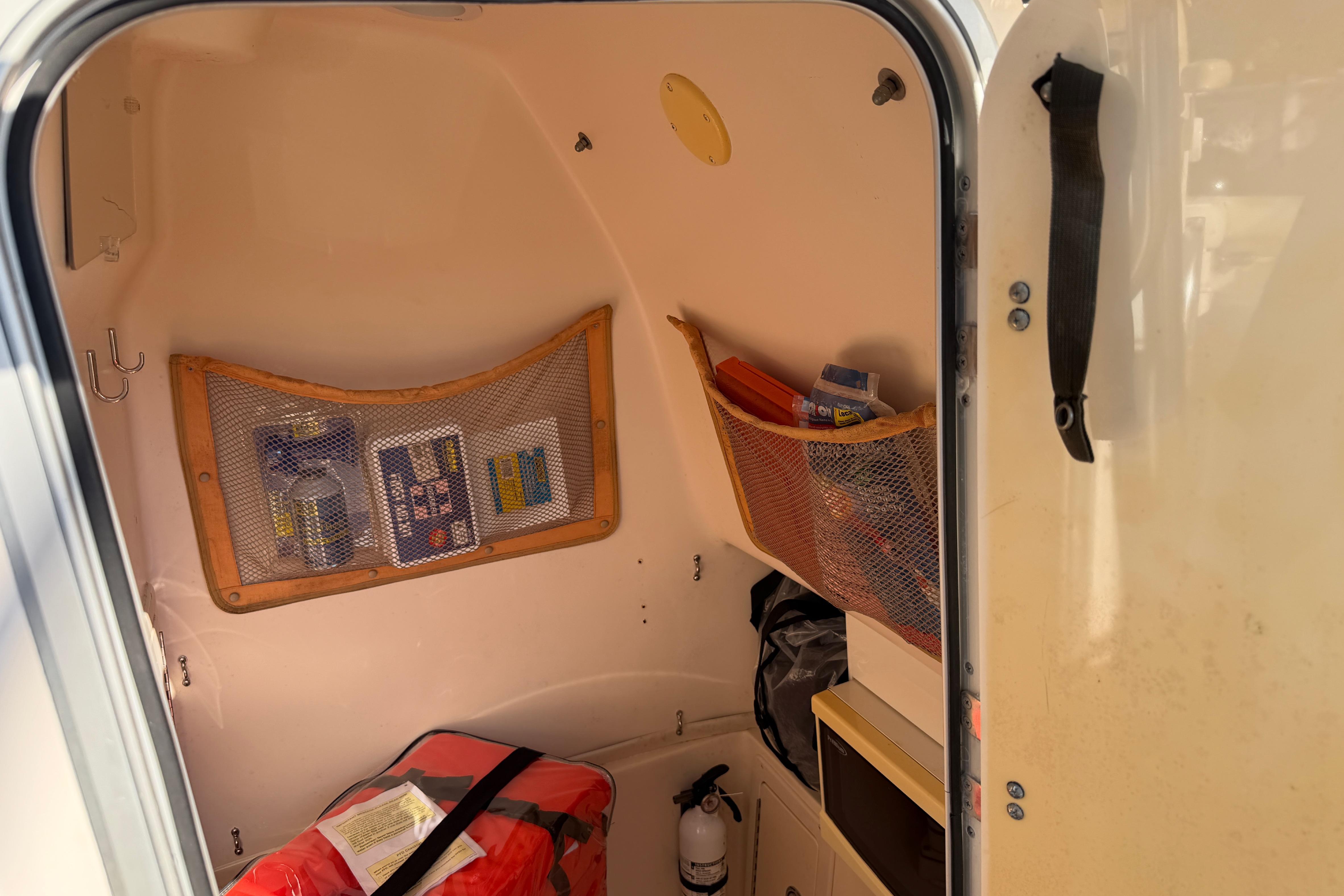 Interior cabin of 2004 Grady White 273 boat with storage nets and safety equipment.