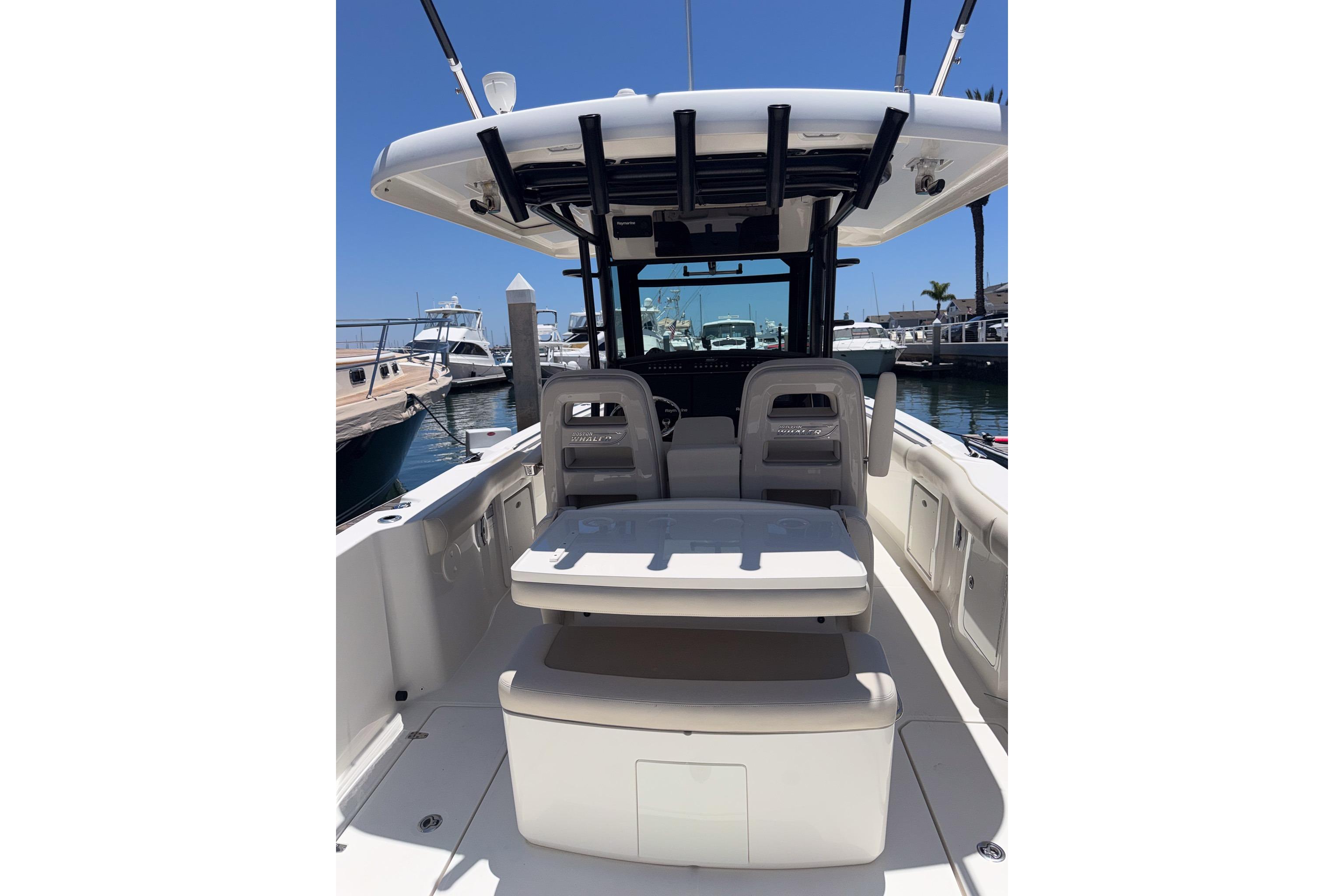 2021 Boston Whaler 330 Outrage boat interior, featuring seating and helm, docked at marina.