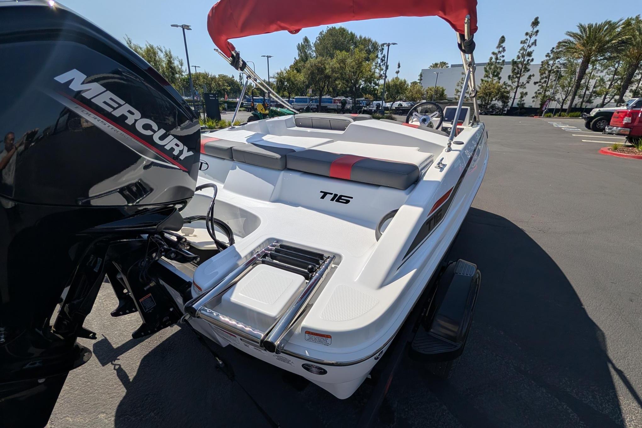 2026 Tahoe T16 boat with Mercury engine, parked outdoors under a red canopy.