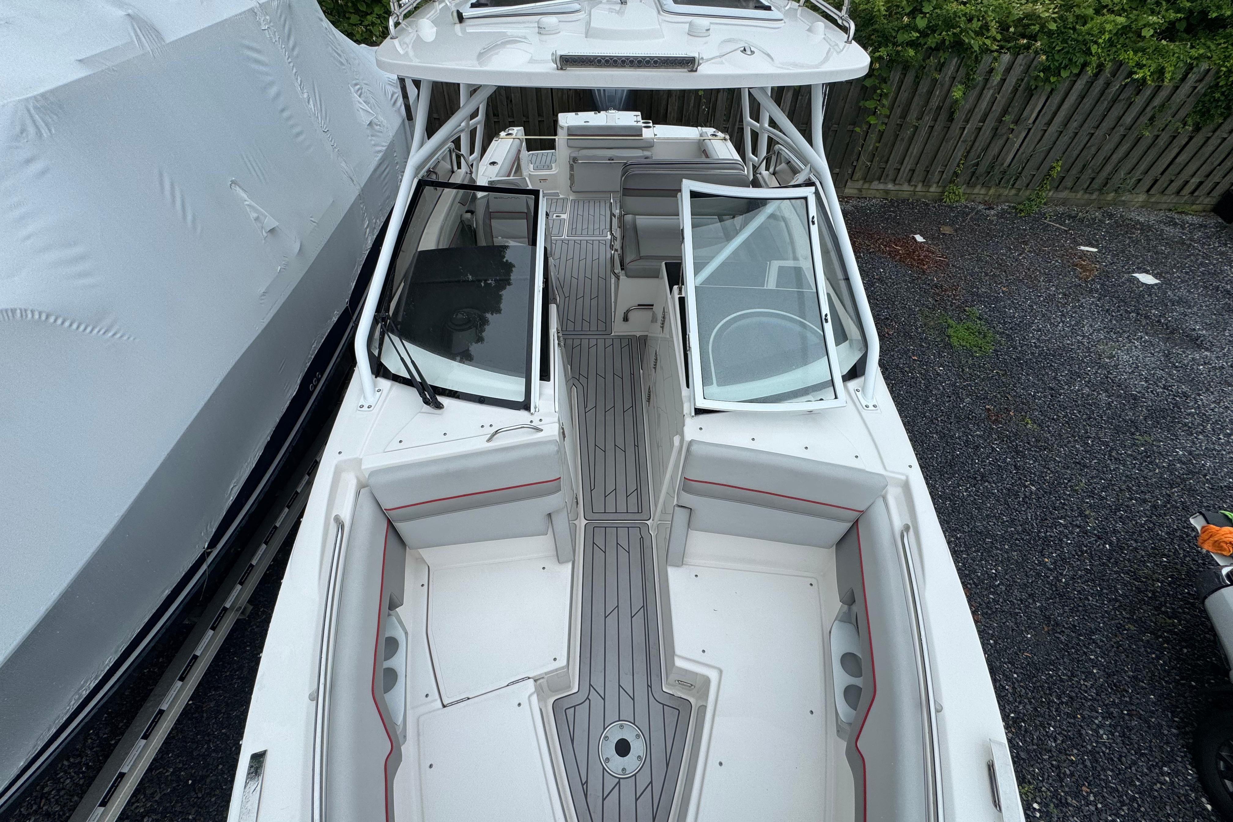 2023 Solara S-250 DC boat with sleek design and spacious seating, docked outdoors.