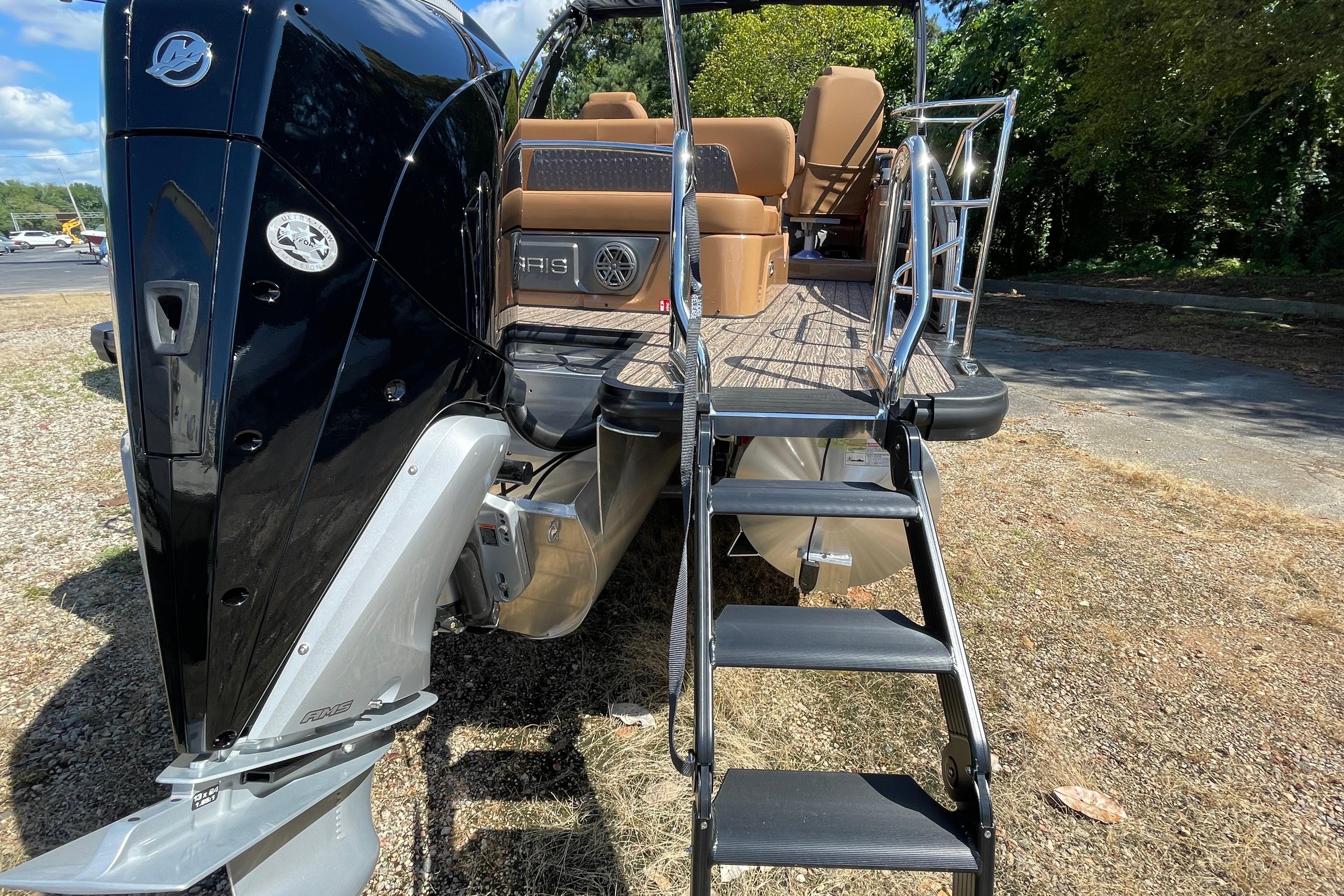 2026 Harris Solstice 250 SLDH pontoon boat with rear ladder and seating, parked outdoors.