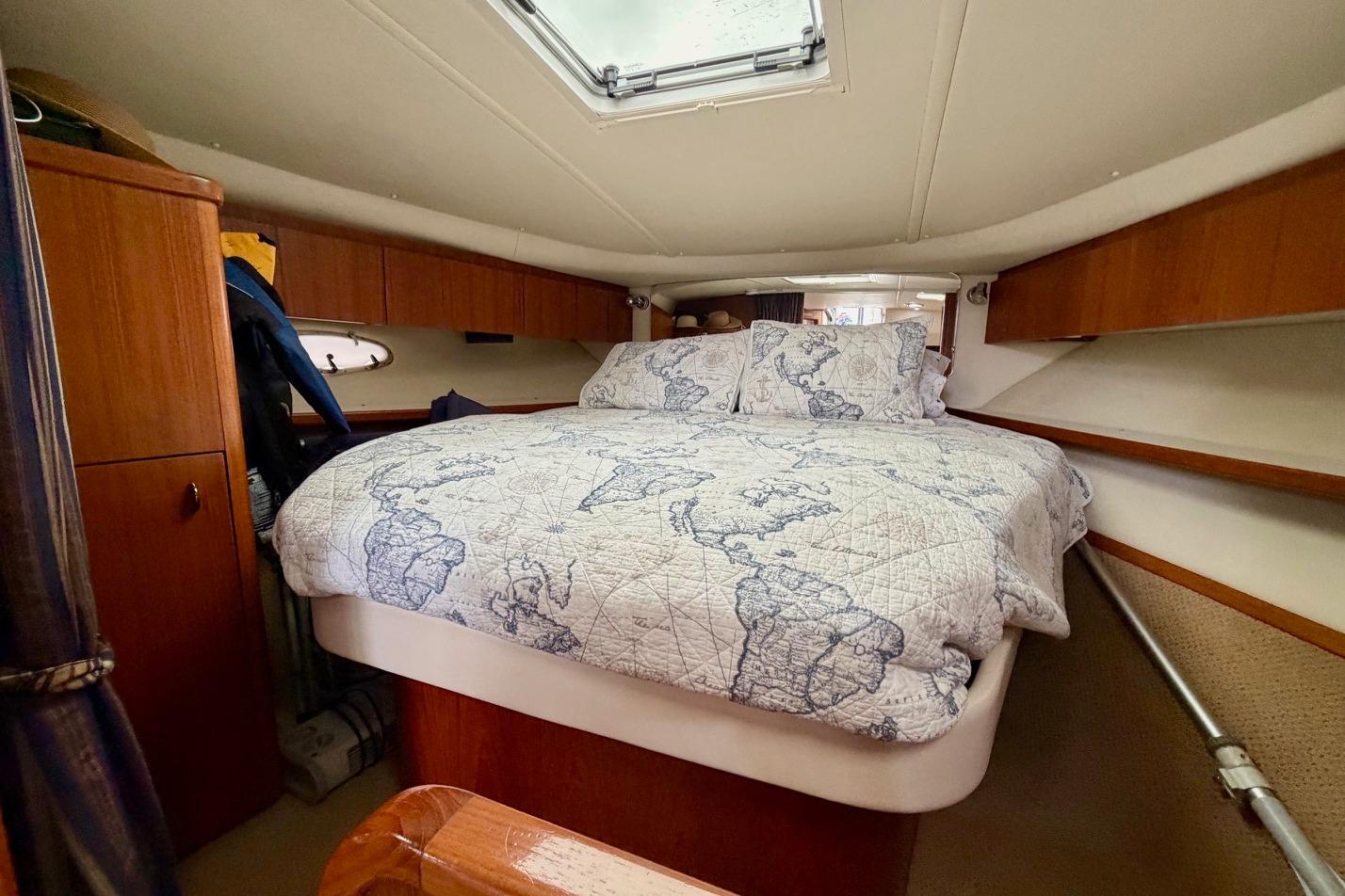 Cozy cabin interior of 2003 Tiara Yachts 3500 Open with map-themed bedding.