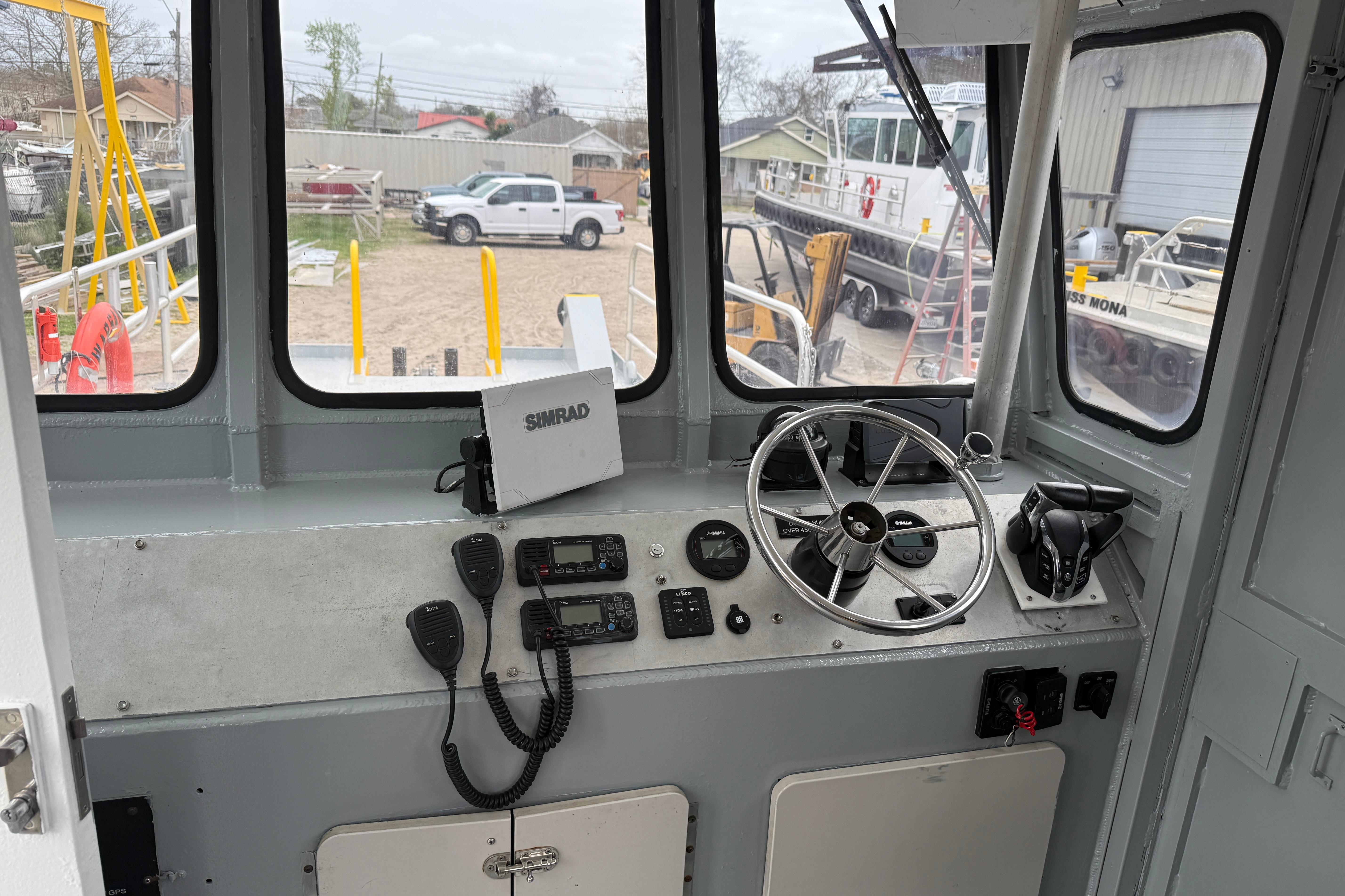 Interior of 2010 Custom Aluminum Work Boat 34x10 with steering wheel and navigation equipment.