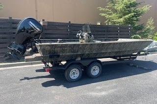 2026 Tracker Grizzly 2072 CC boat on trailer, parked outdoors.