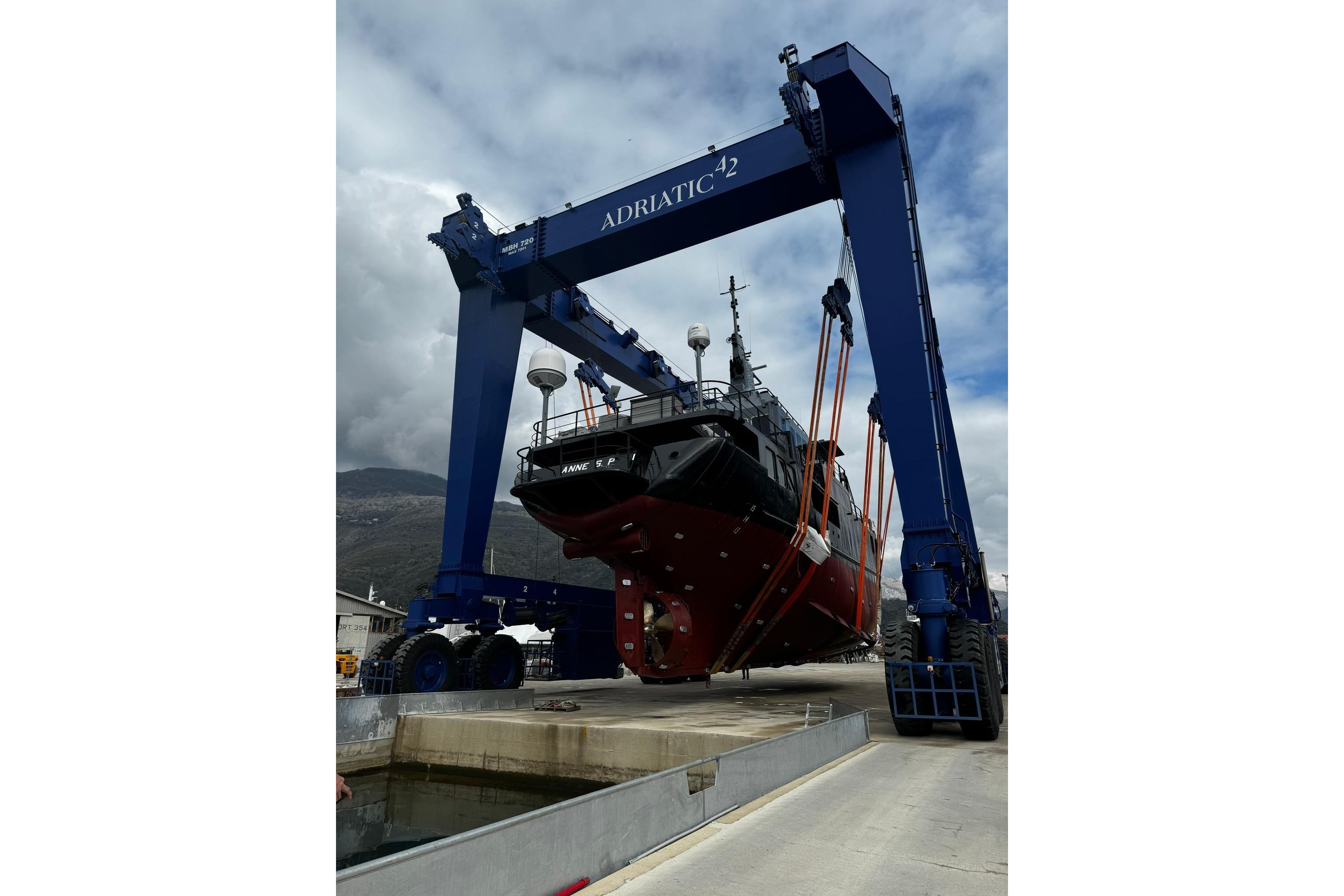 Large ship being lifted by blue crane at Glovertown Shipyard, 2021.
