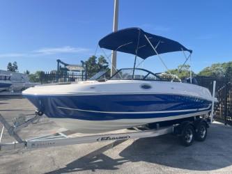 2022 Bayliner VR6 boat with blue hull on a trailer, parked outdoors.