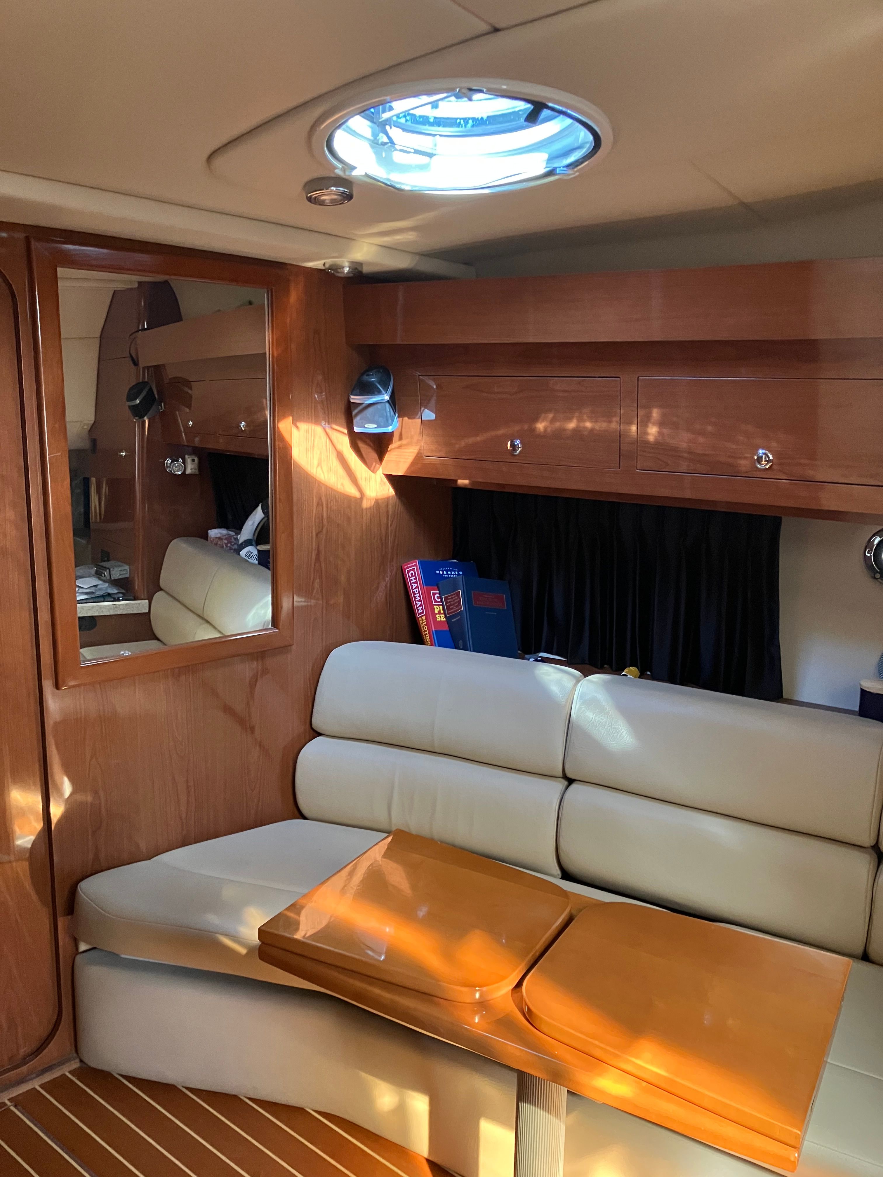 Interior of a 2008 Custom Commodore yacht with leather sofa and wooden table.
