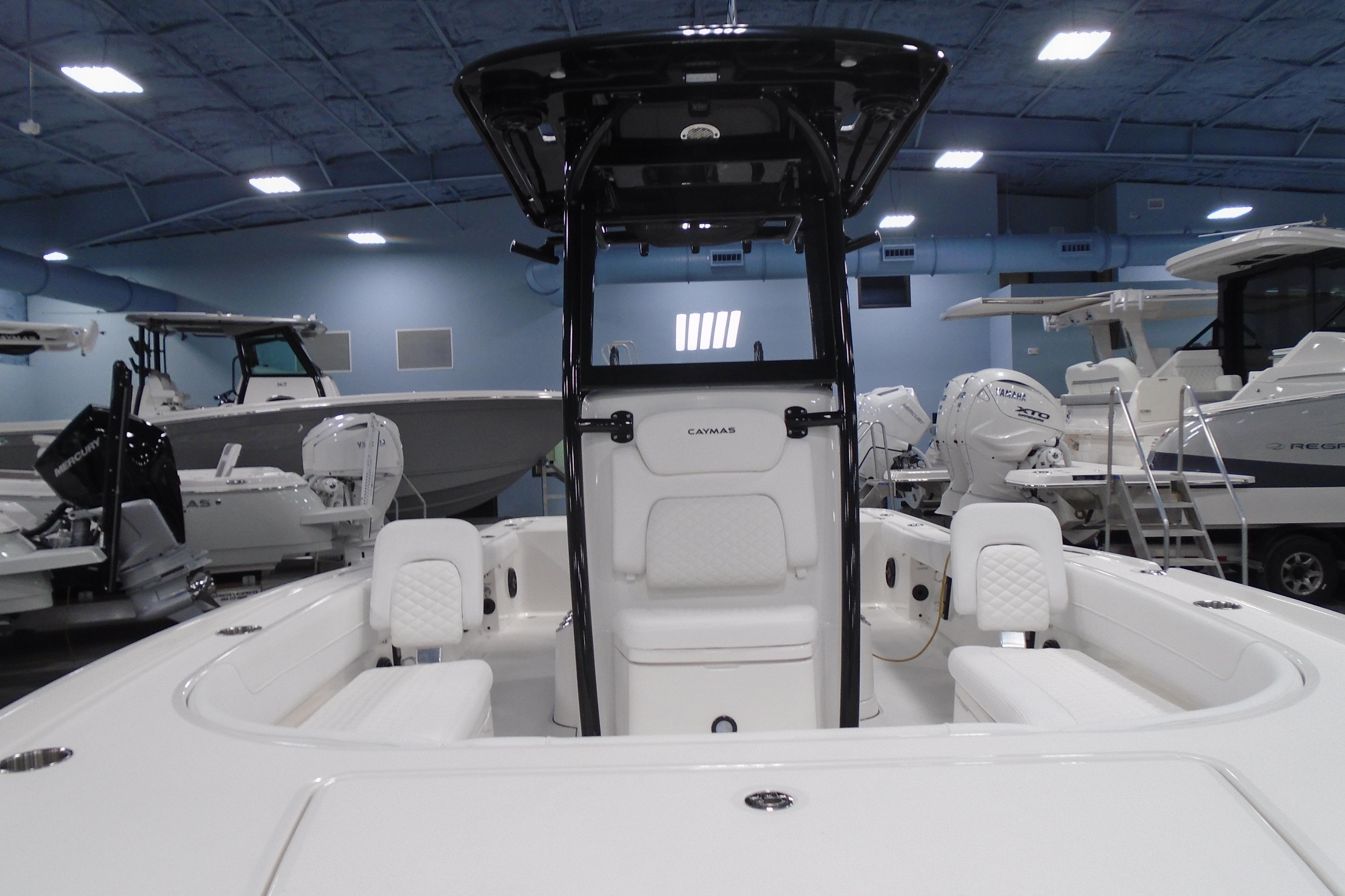 2026 Caymas 26 HB boat interior in showroom, featuring sleek design and modern seating.