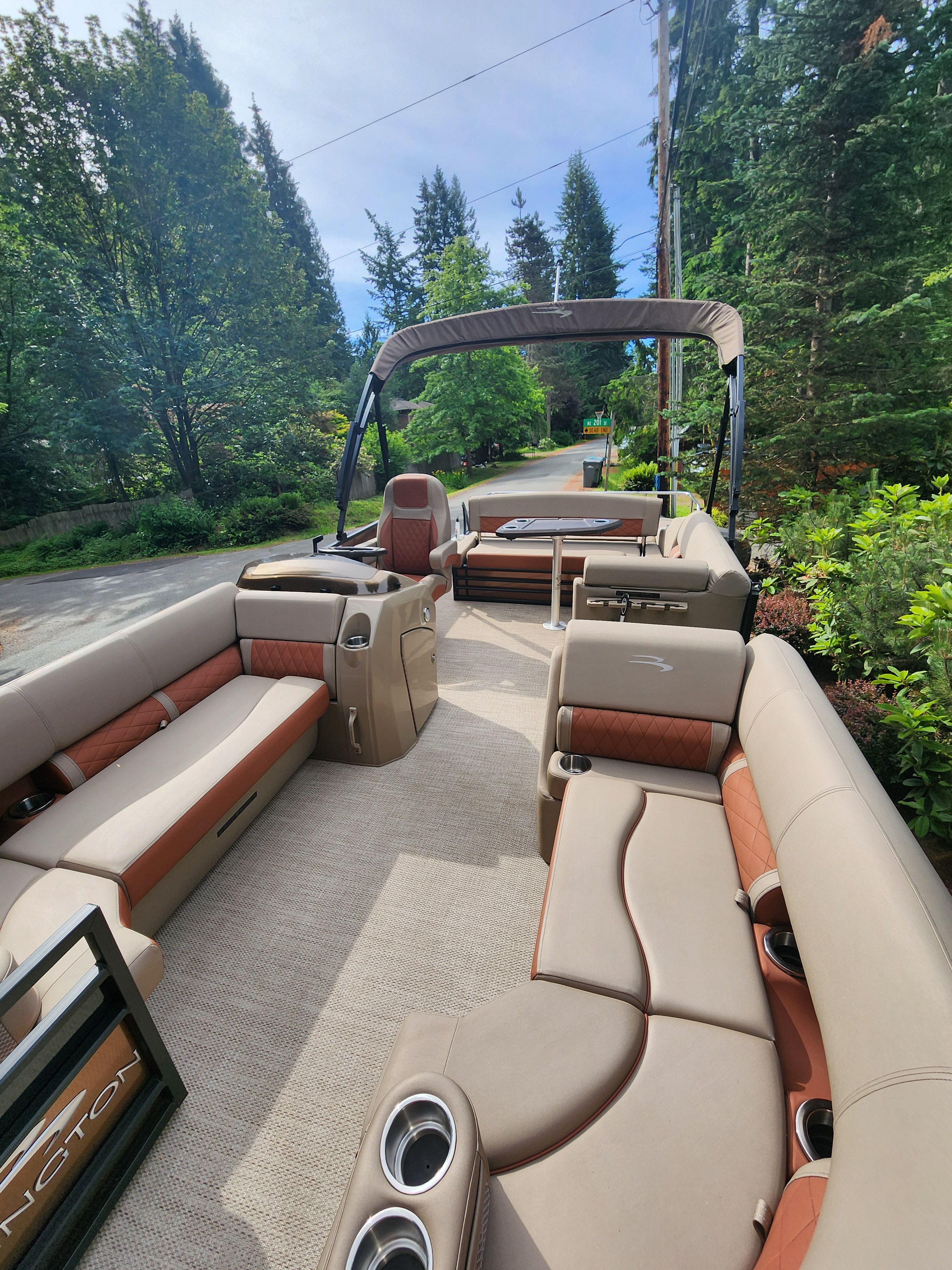 2023 Bennington 22 LSB with luxurious seating and open deck, surrounded by trees.