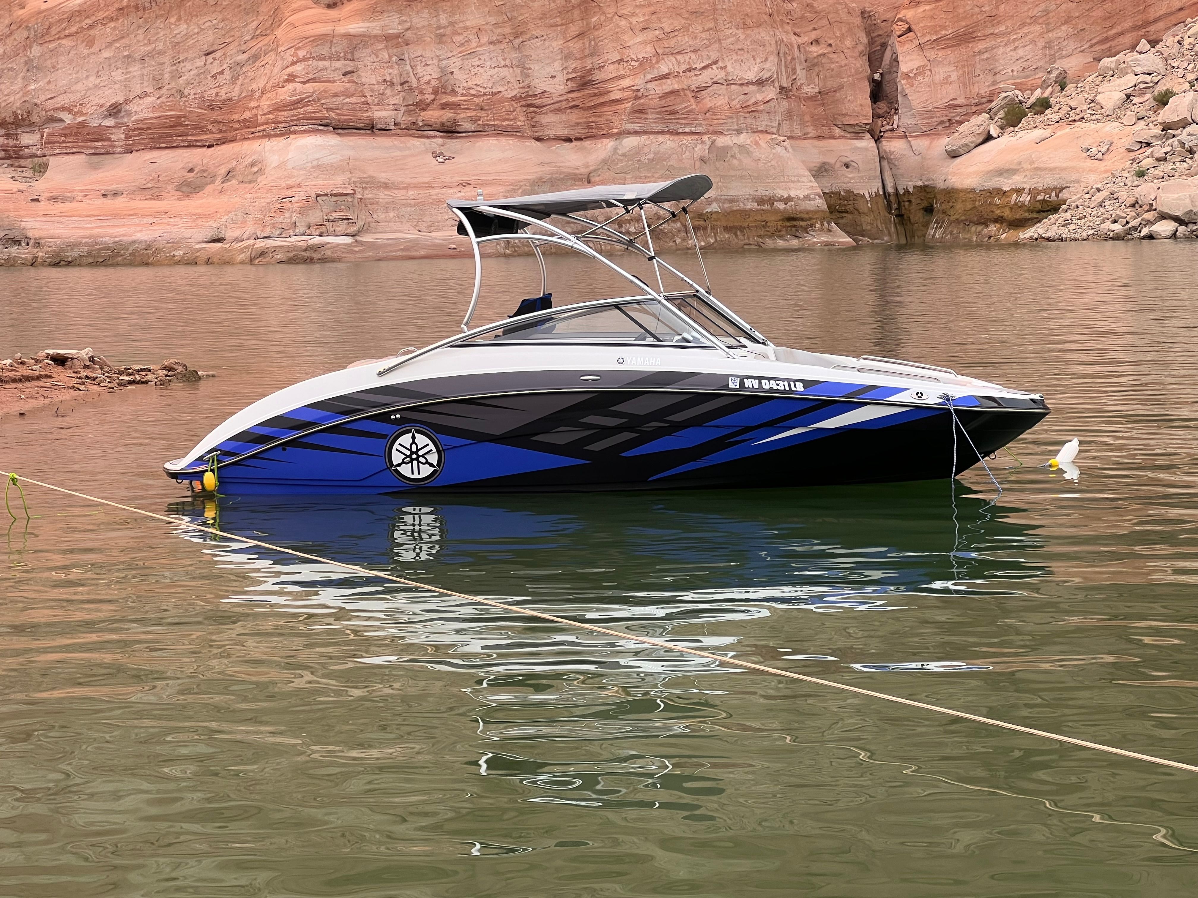 2011 Yamaha AR240 HO boat on calm water with rocky backdrop.