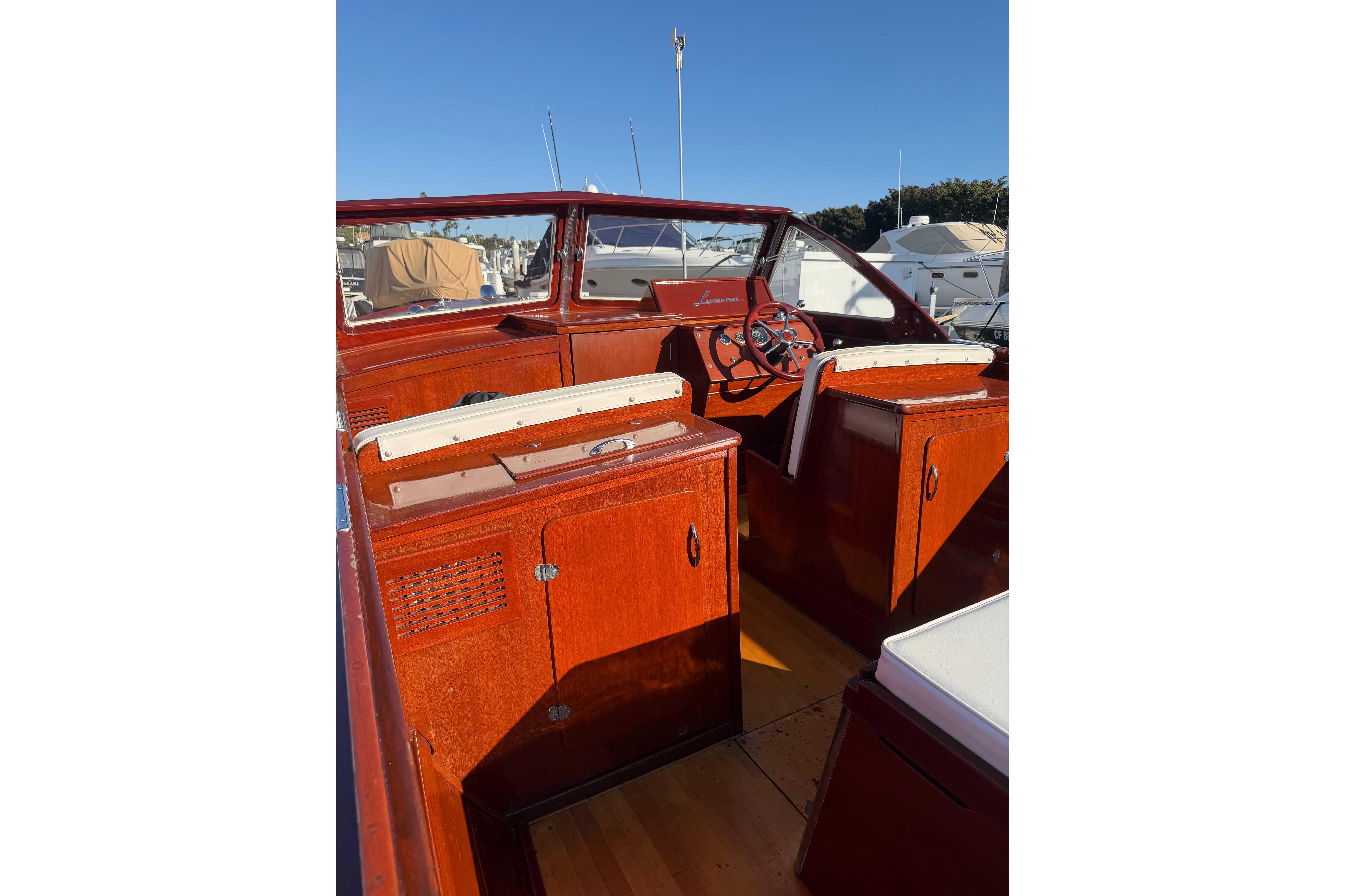 1964 Lyman 25 Sleeper boat interior with wooden finish and steering wheel.