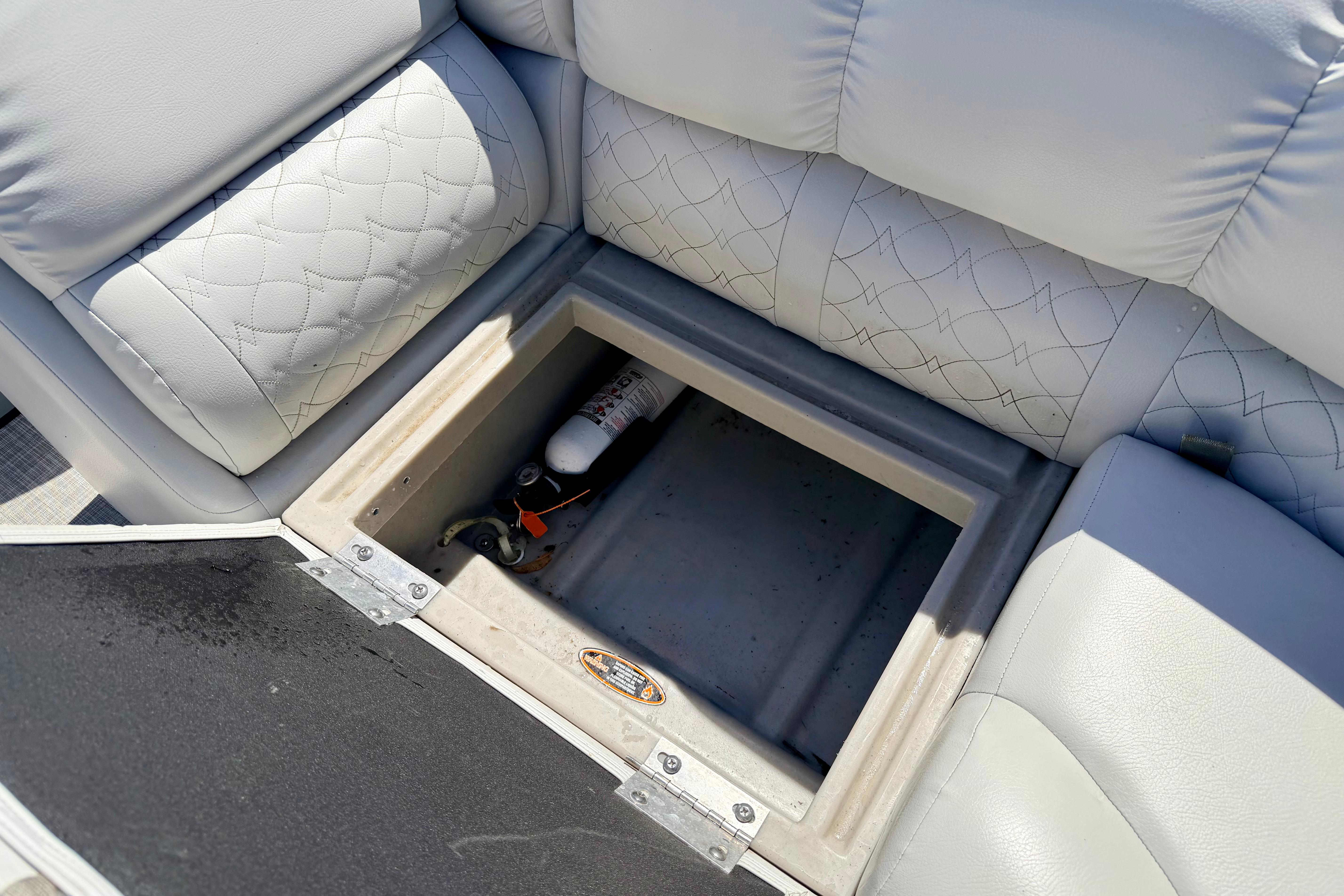 Storage compartment in 2019 Crestliner 240 Rally DX CW boat with fire extinguisher.