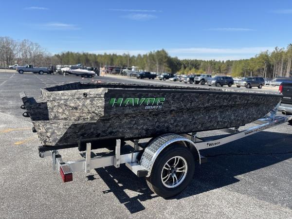 2025 Havoc 1656 VJST boat on trailer, camo design, parked in outdoor lot.