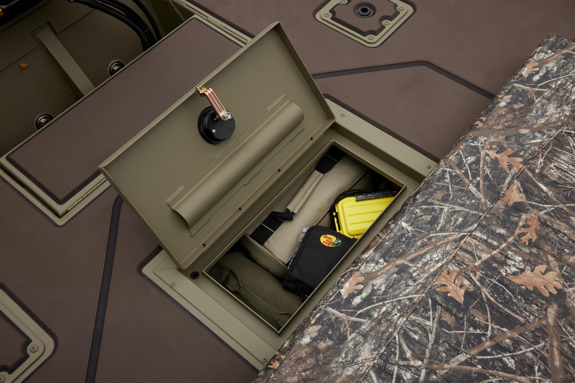 Storage compartment in 2025 Tracker Grizzly 2072 CC boat with camo pattern and gear.