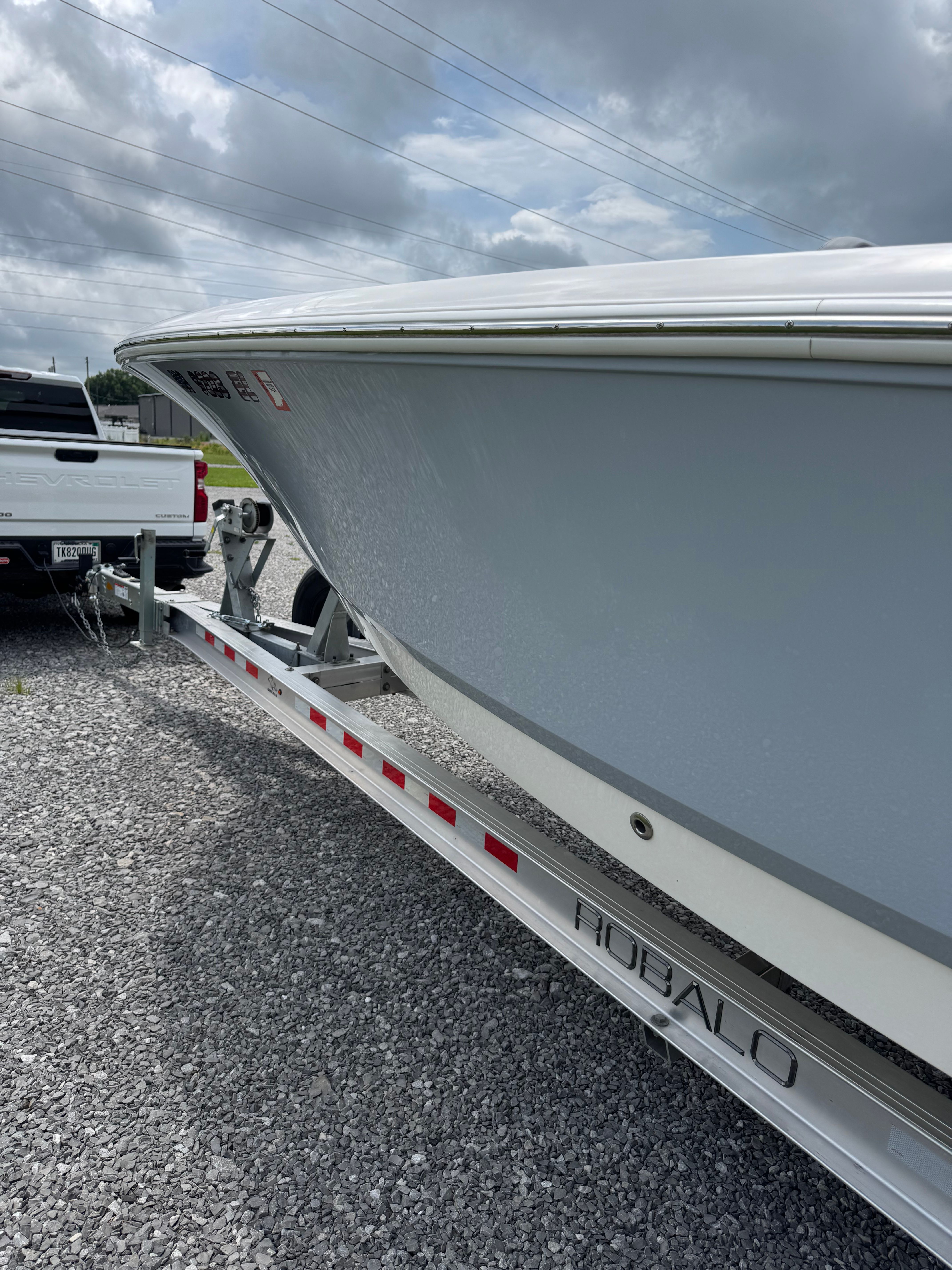 A 2023 Robalo 266 Cayman boat on a trailer, ready for transport.