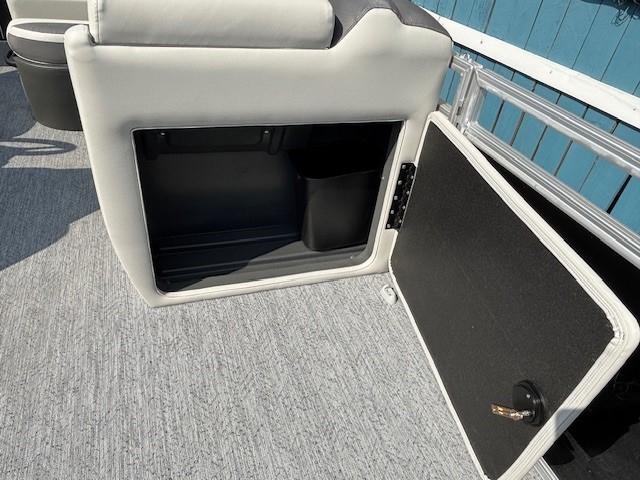 2026 Sun Tracker Fishin' Barge 20 DLX storage compartment with open door, gray interior.