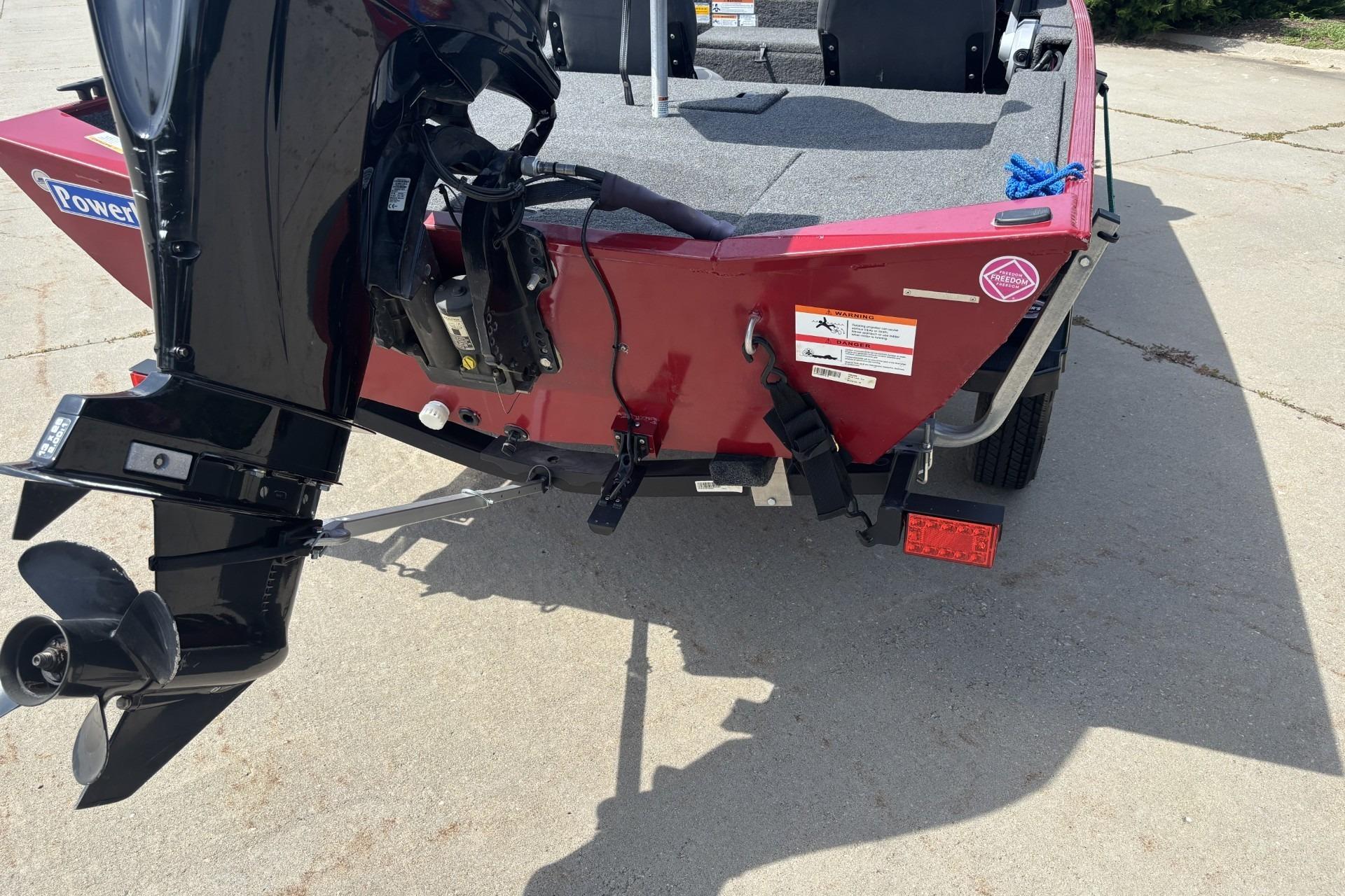 2019 Lowe Skorpion 17 boat rear view with motor and trailer on pavement.