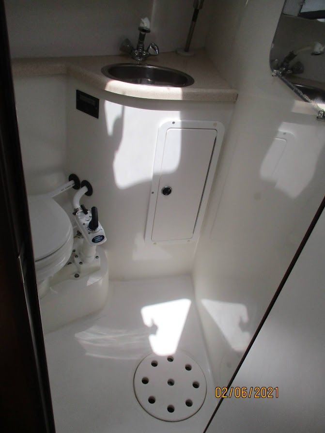 The image shows a boat bathroom with a toilet, sink, and mirror.