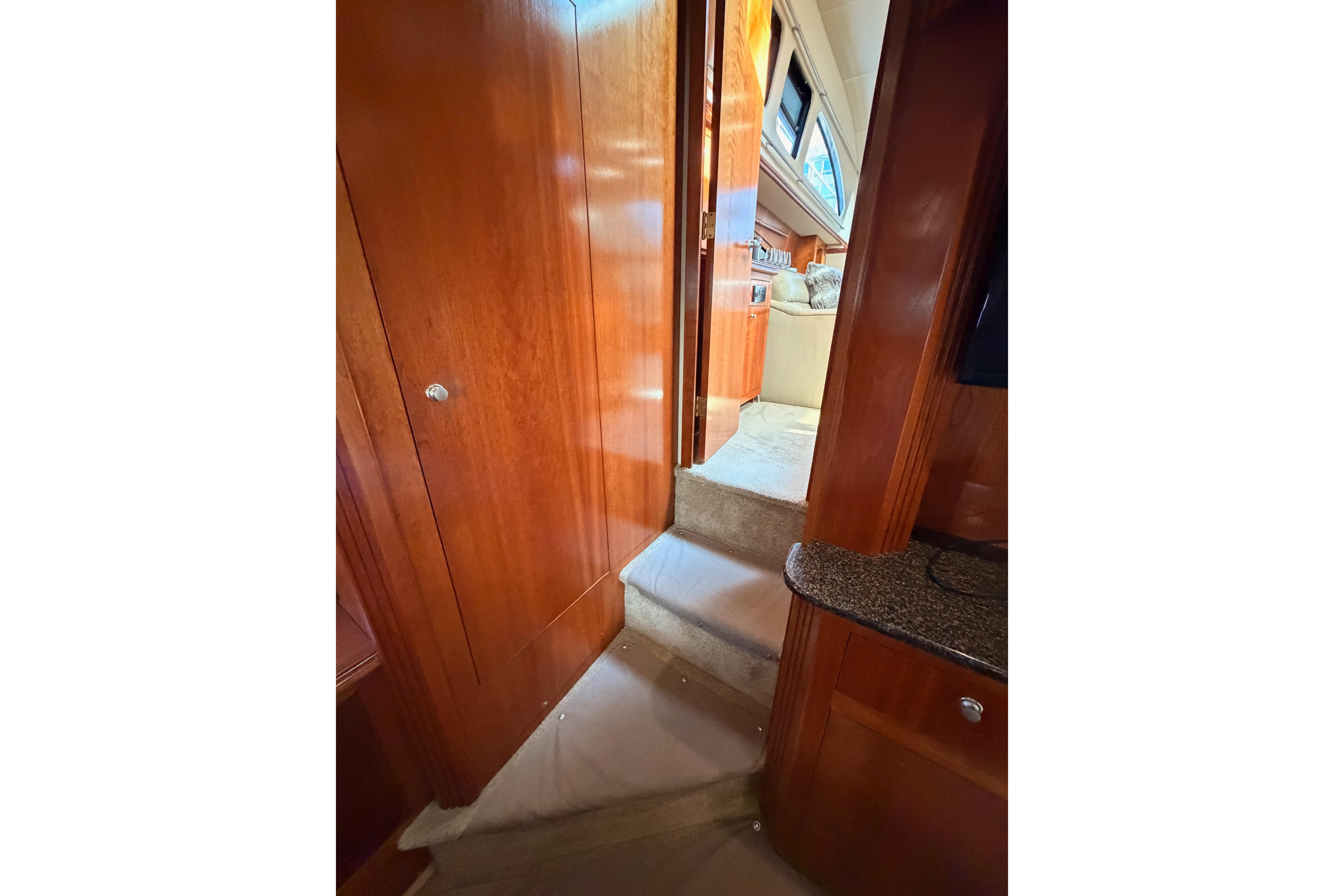 Interior view of 2005 Cruisers Yachts 405 Express Motoryacht with wooden paneling and carpeted steps.