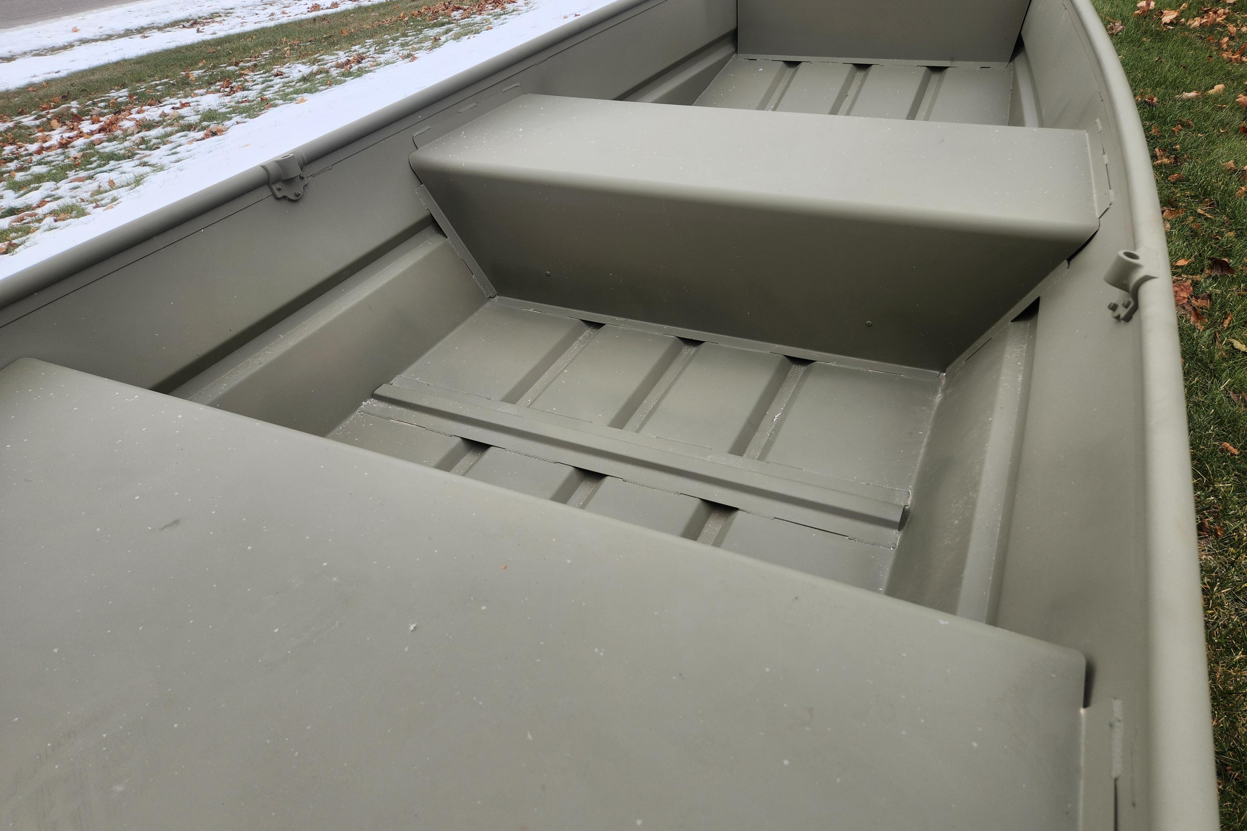 2026 Tracker Grizzly 12 Jon boat interior with bench seats, on grassy area with snow.