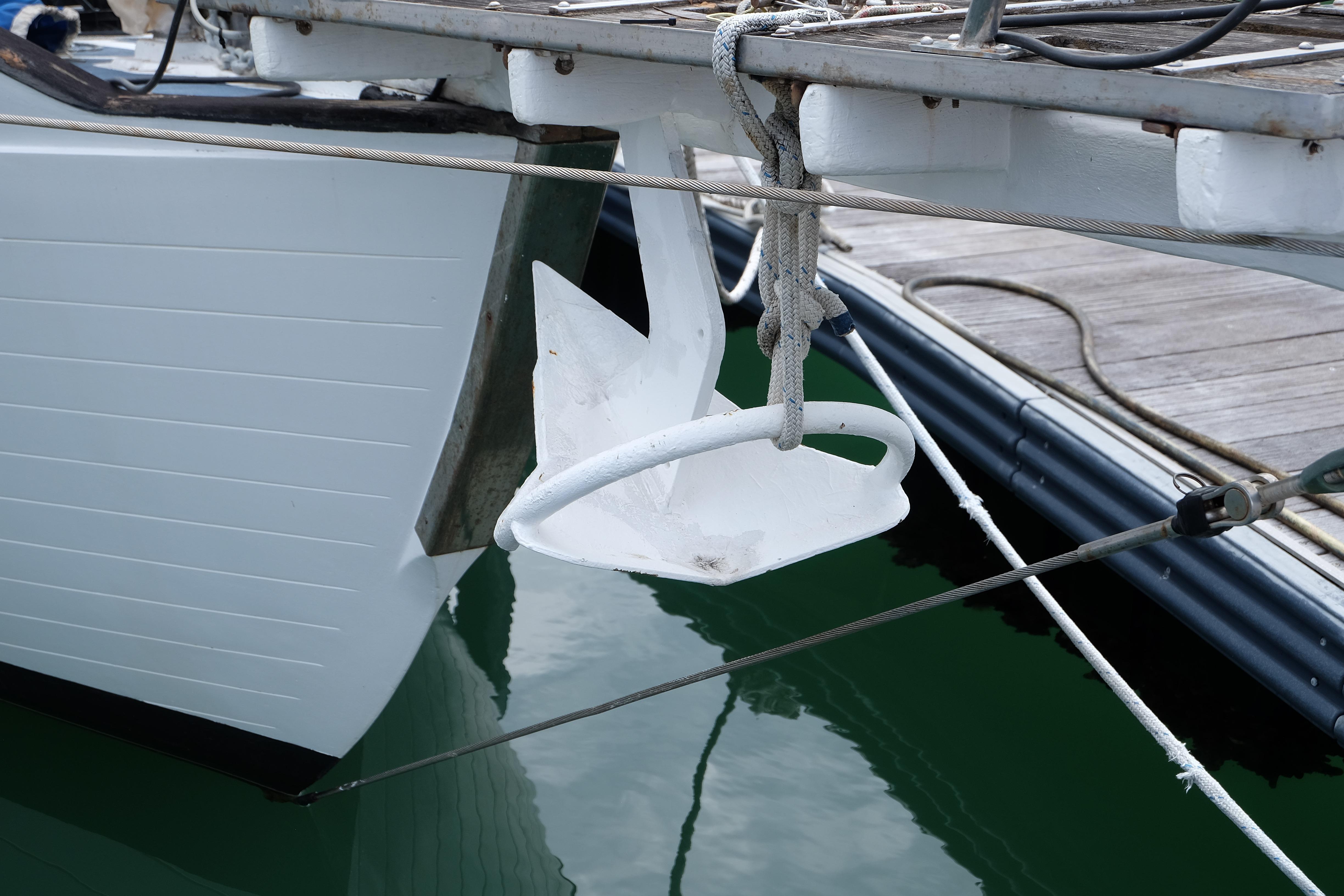 White anchor on a 1979 Westwind 35 sailboat, docked at a marina.