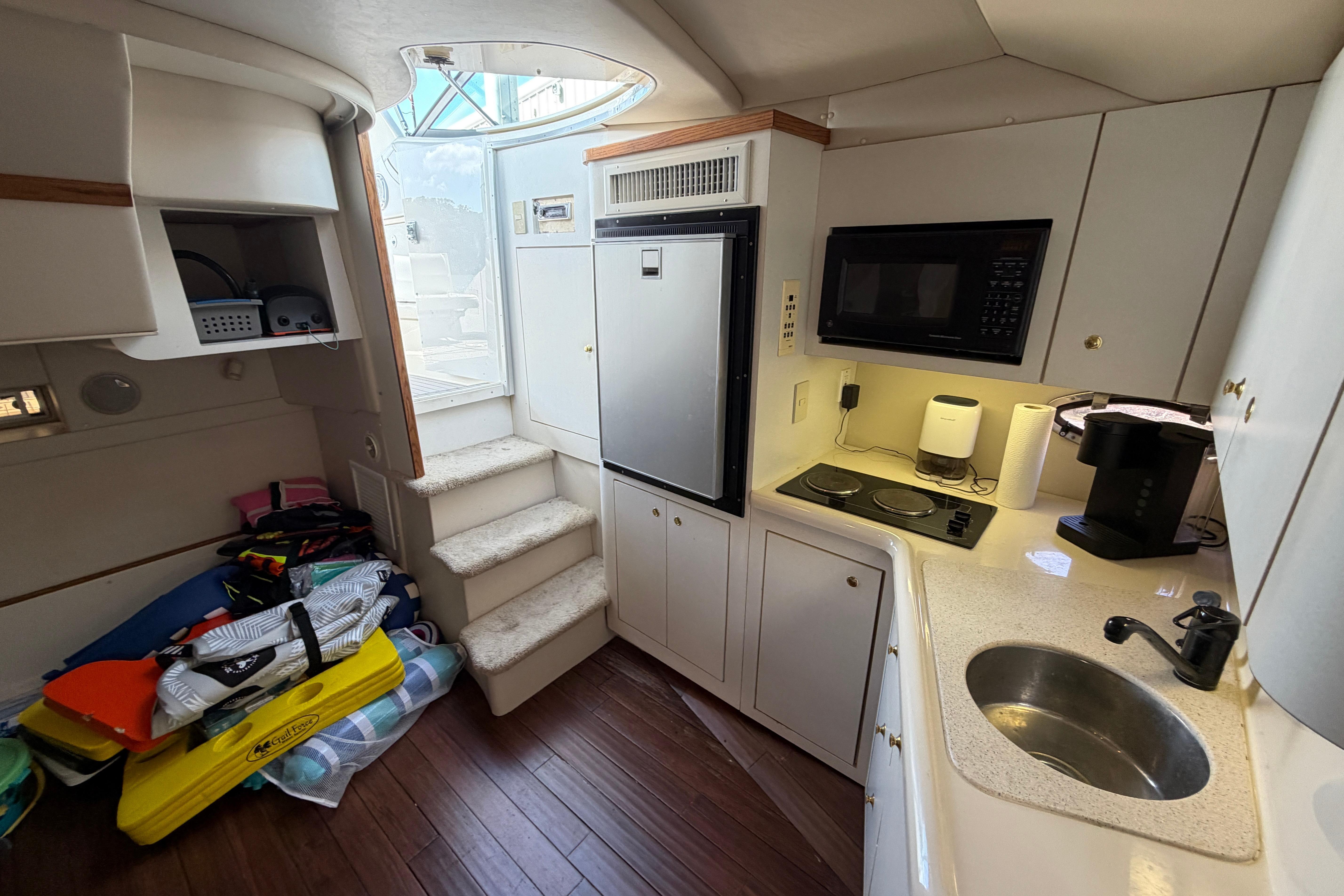 Interior of a 1997 Cruisers 3575 yacht kitchen with appliances and storage.