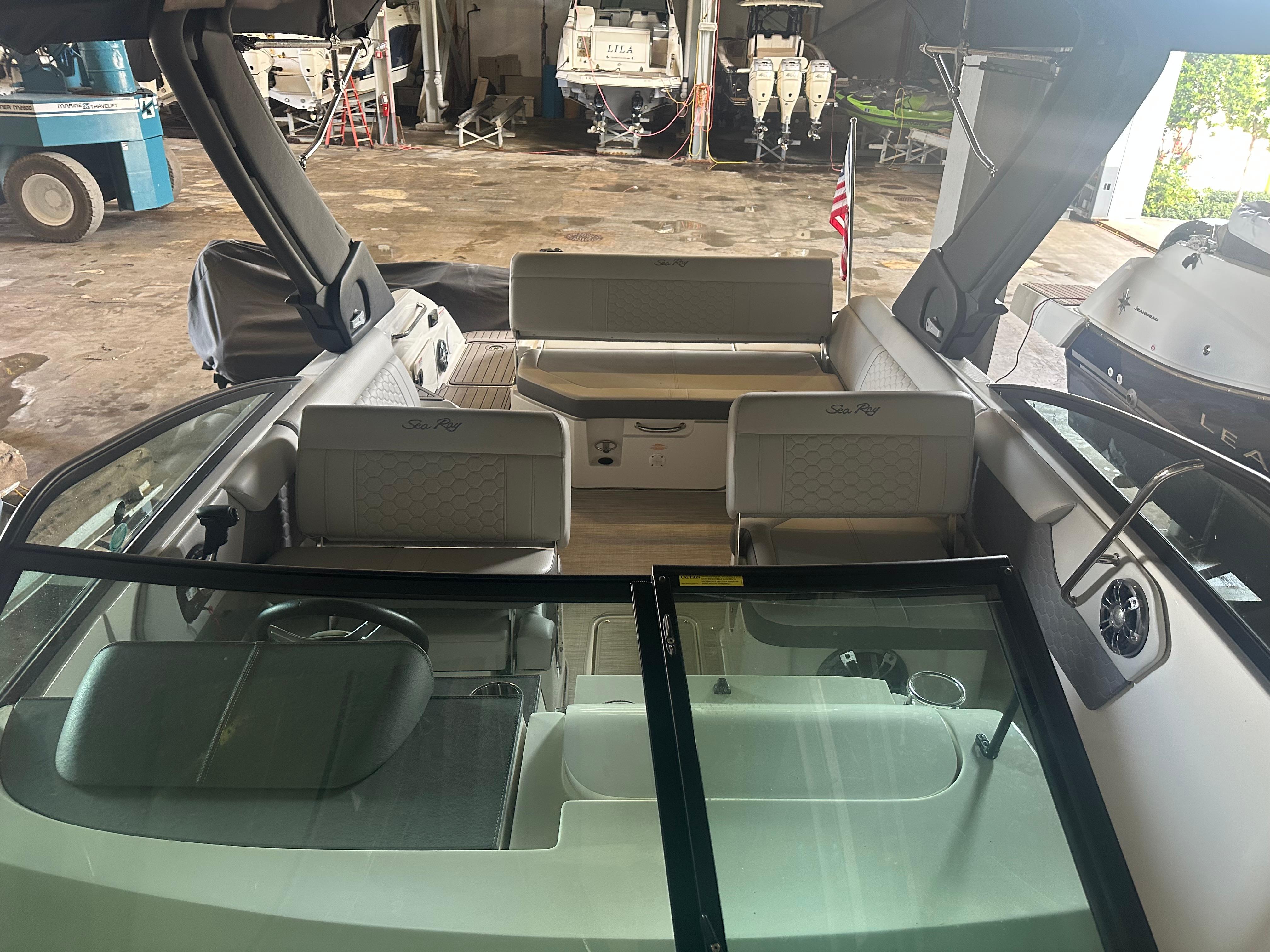 2022 Sea Ray SDX 250 boat interior with seating and windshield in a storage facility.