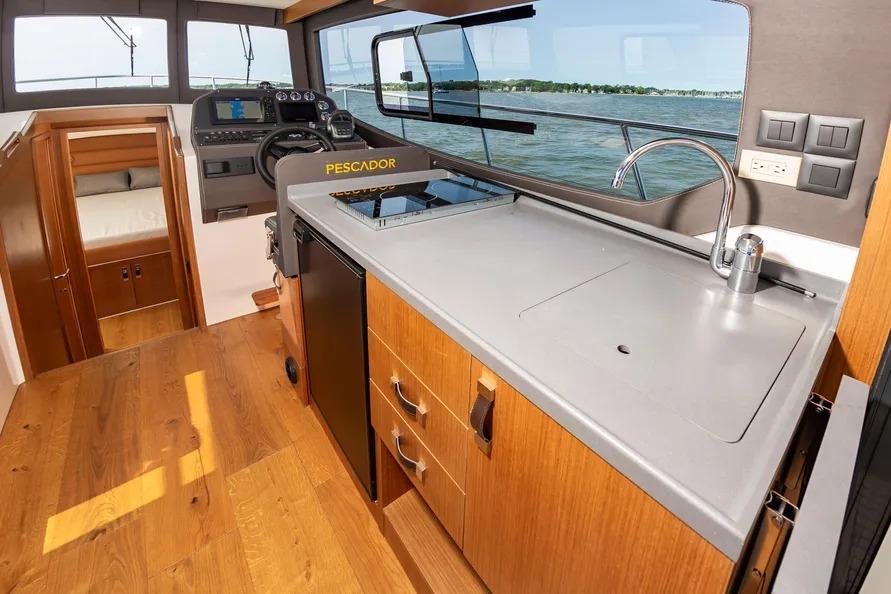 Interior of 2023 Pescador 35 boat with modern kitchen and steering area.