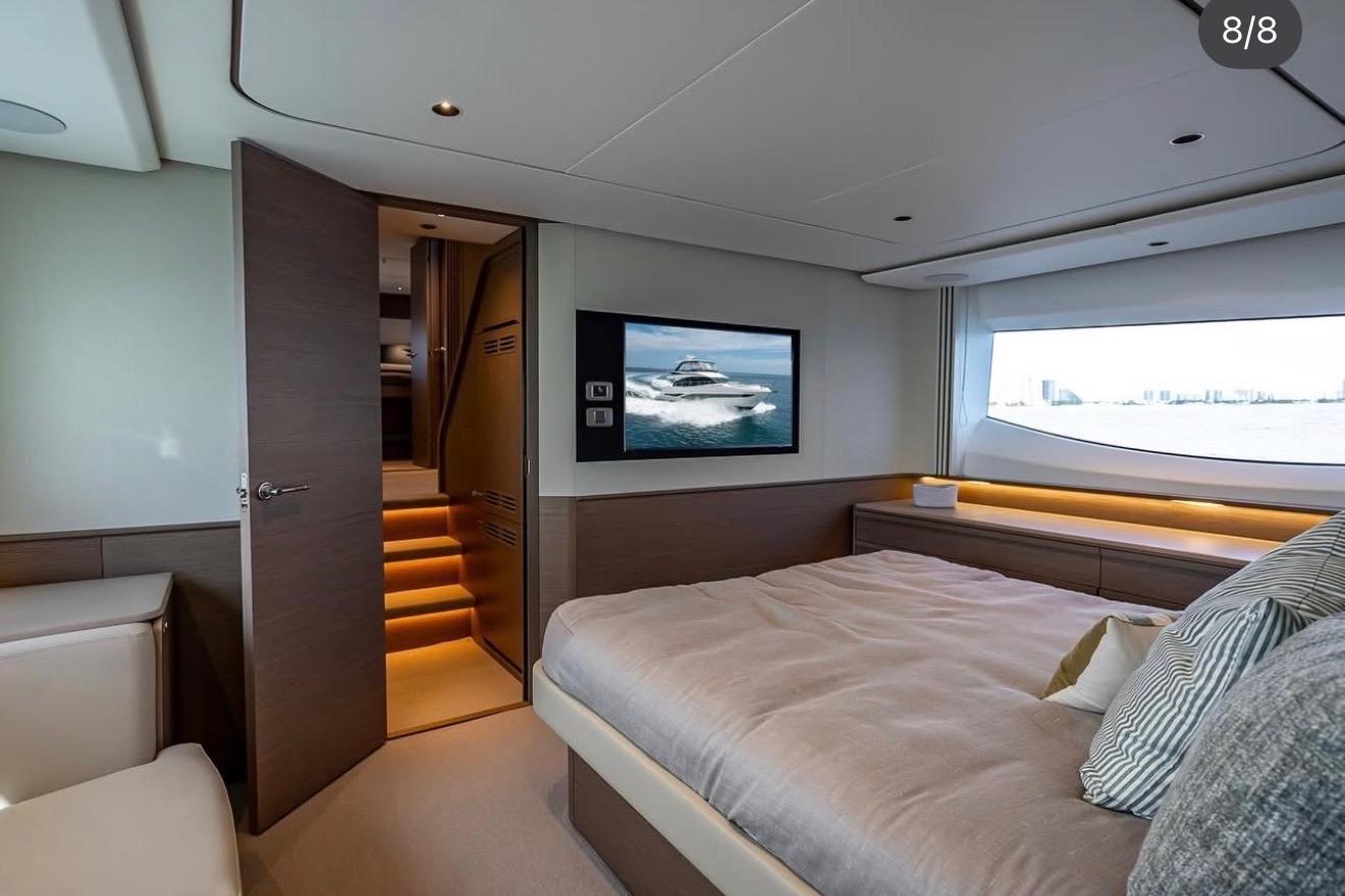 Luxurious bedroom interior of 2023 Princess F65 yacht with modern design and scenic window view.