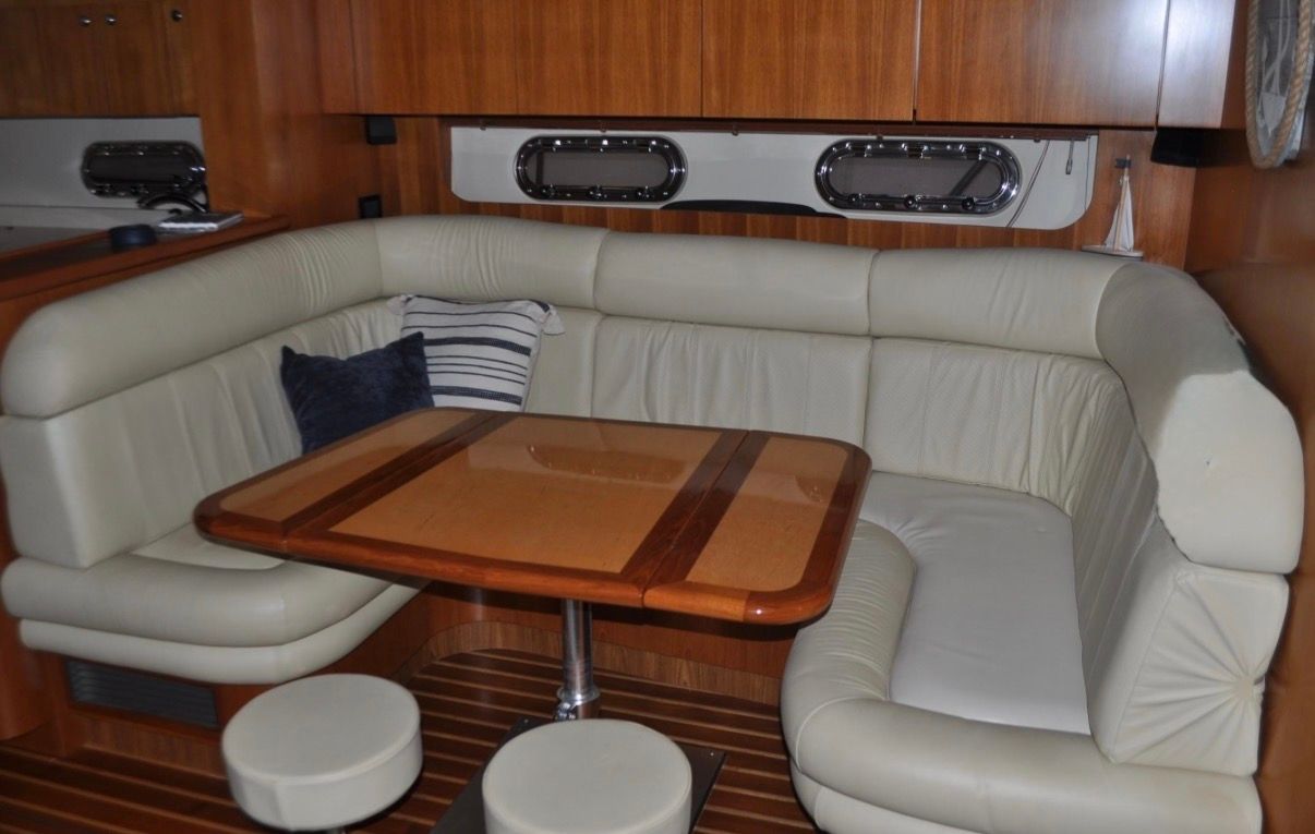 Interior of the 2005 Tiara Yachts 5200 Sovran with beige leather sofa and wooden table.