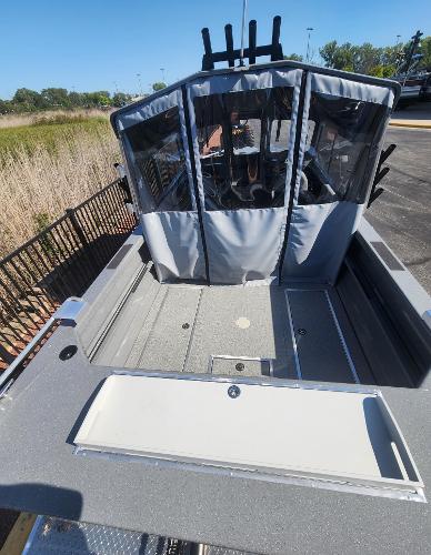 2025 Spartan 200 Astoria boat with enclosed cabin, docked outdoors.