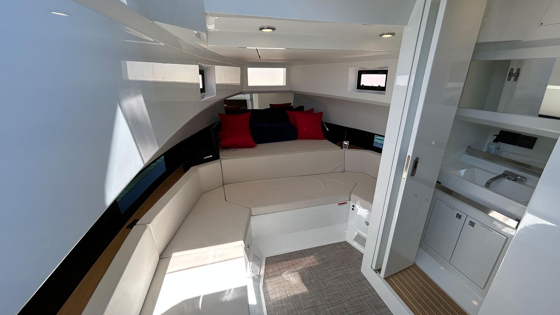 Interior of 2025 De Antonio Yachts D36, featuring modern seating and compact kitchenette.