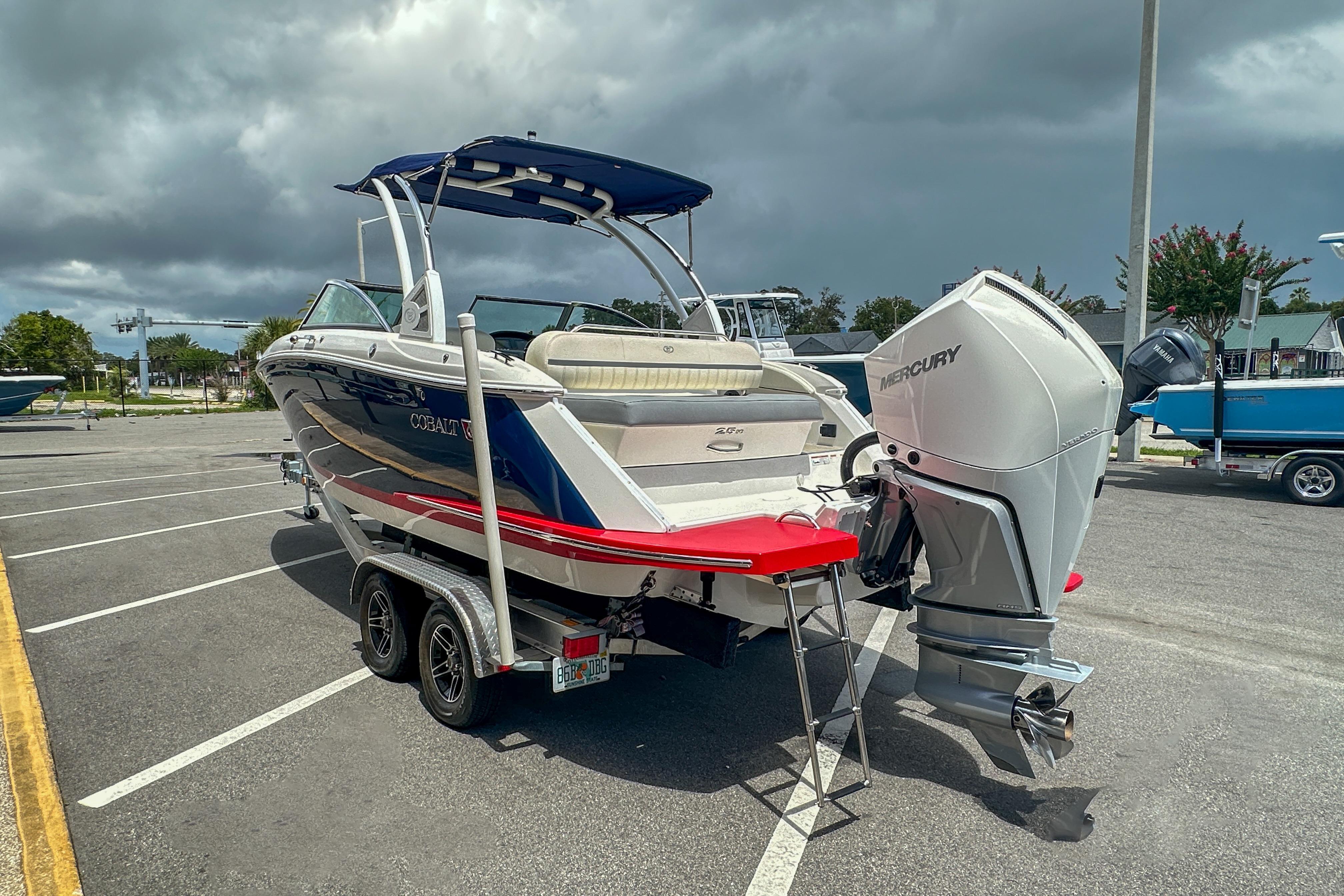 2022 Cobalt 25SC boat with Mercury outboard engine in parking lot.