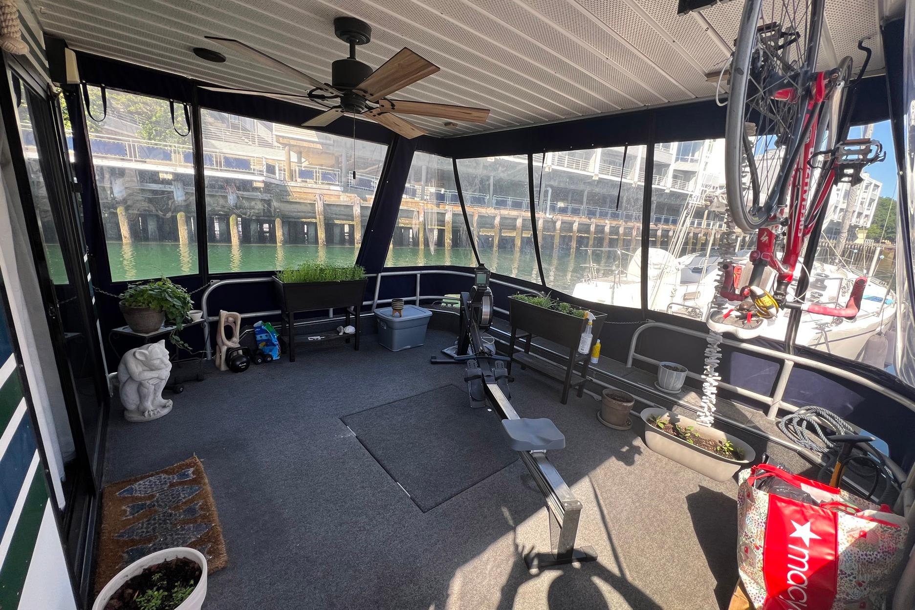 1993 Sumerset houseboat interior with exercise equipment, plants, and waterfront view.
