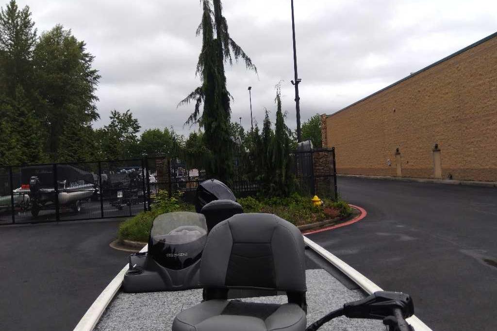 2026 Tracker Pro 170 boat parked near a fenced area and trees.