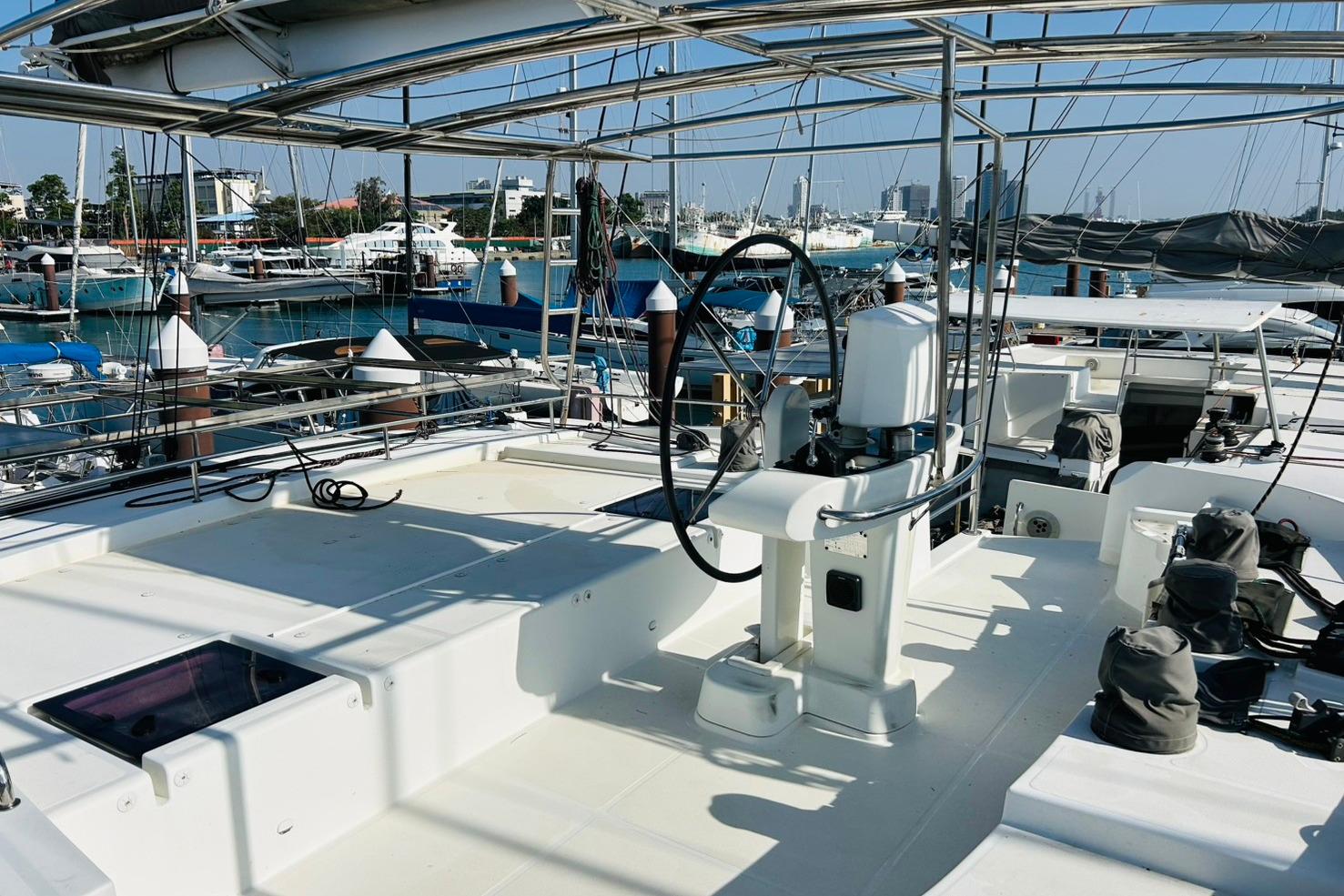 Lagoon 52F 2013 yacht at marina, featuring spacious deck and steering wheel.