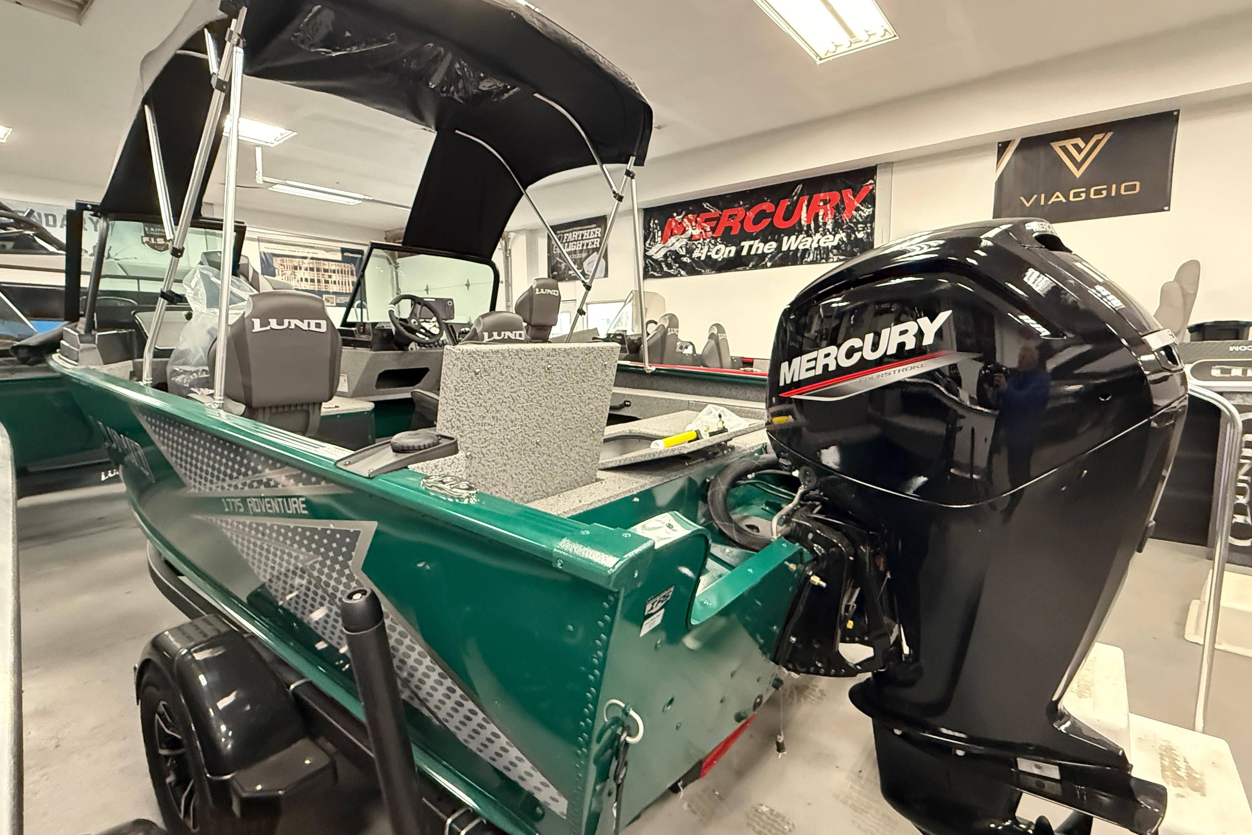 2026 Lund 1775 Adventure Sport boat with Mercury engine in showroom.