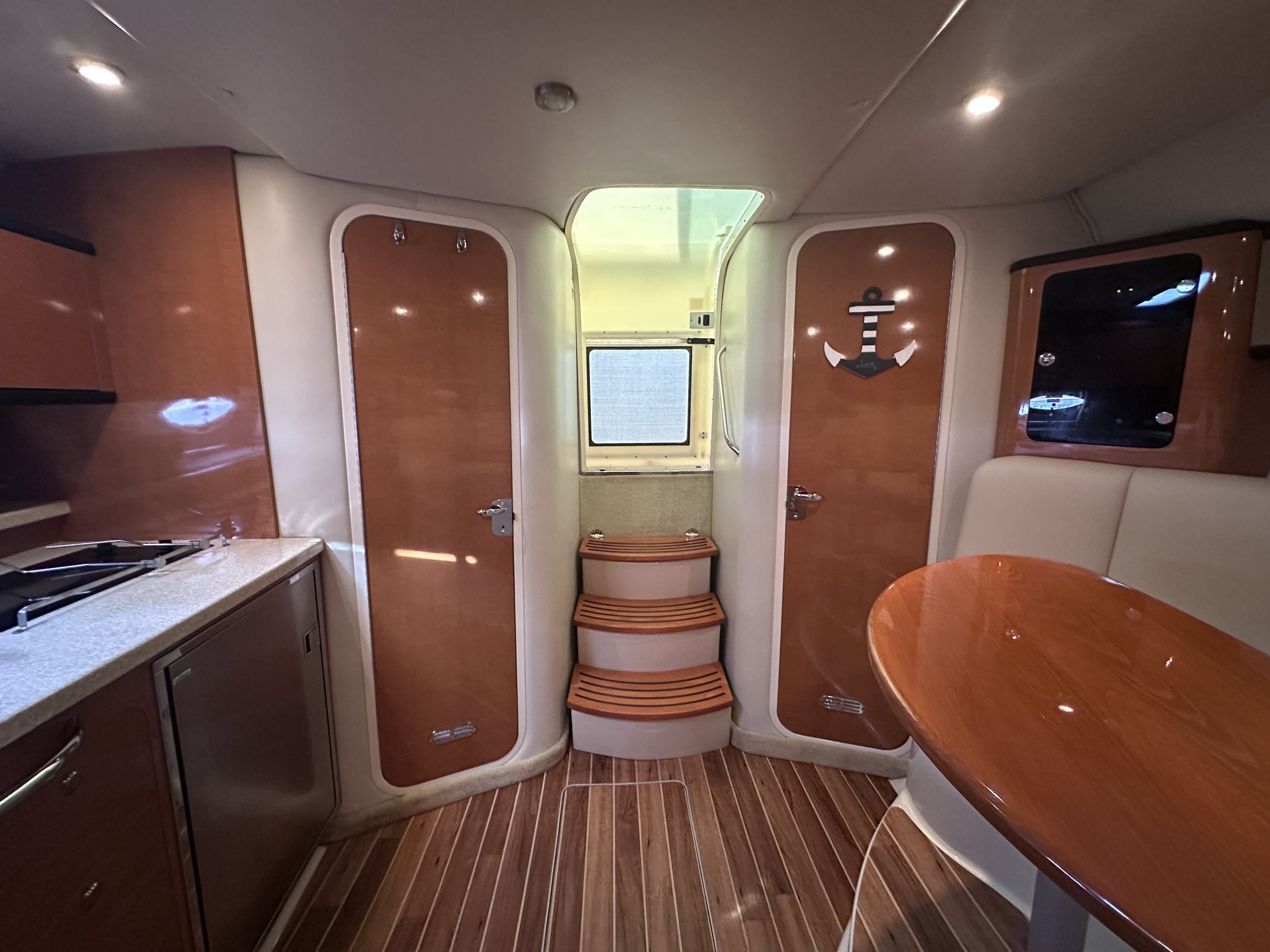 Interior of the 2008 Chaparral Signature 330 with wood flooring, kitchenette, and dining table.