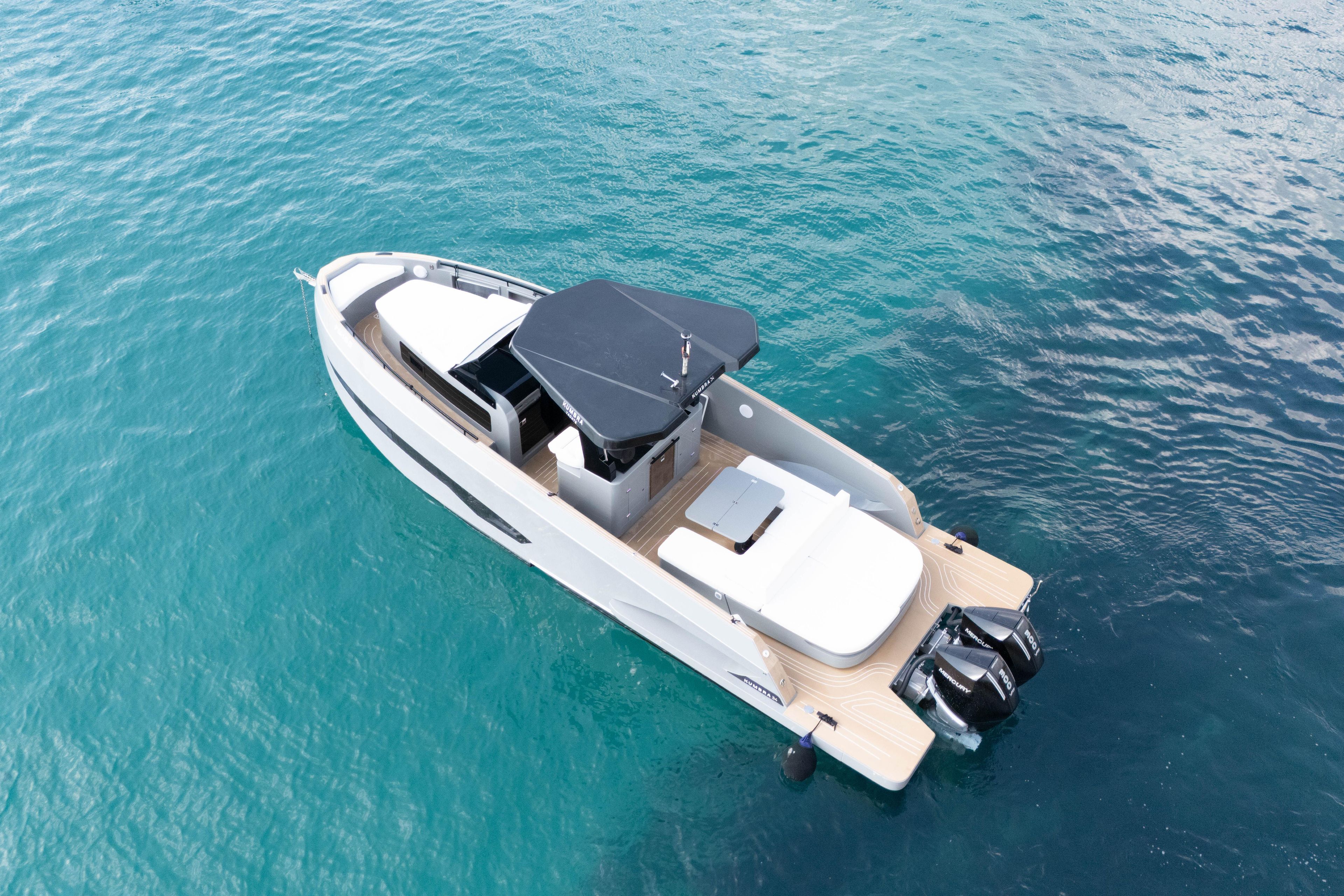 2025 Kumbra 34 boat on clear blue water, featuring sleek design and dual engines.