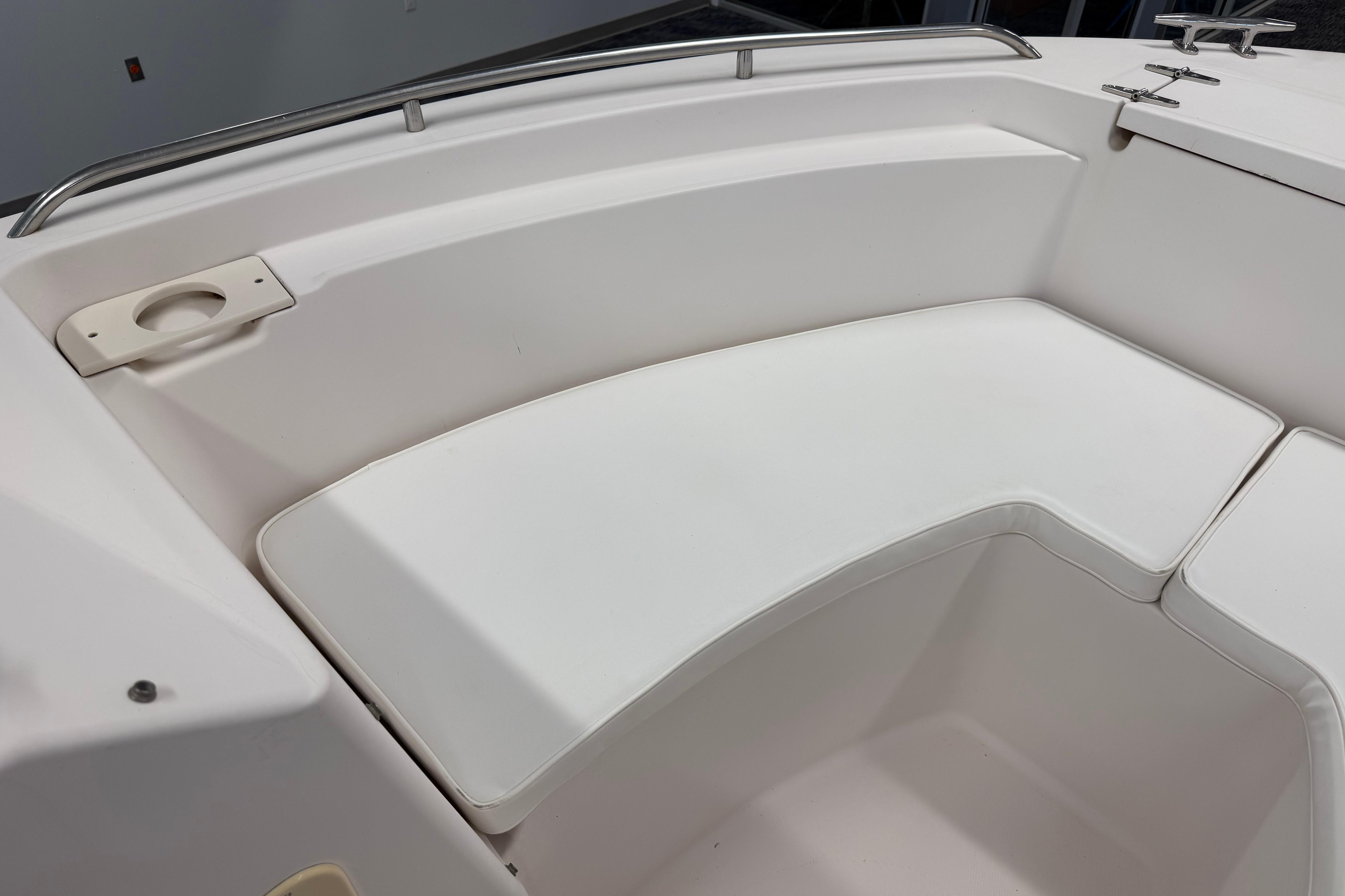 2001 Grady-White Tournament 223 boat seating area with white cushions and cup holder.