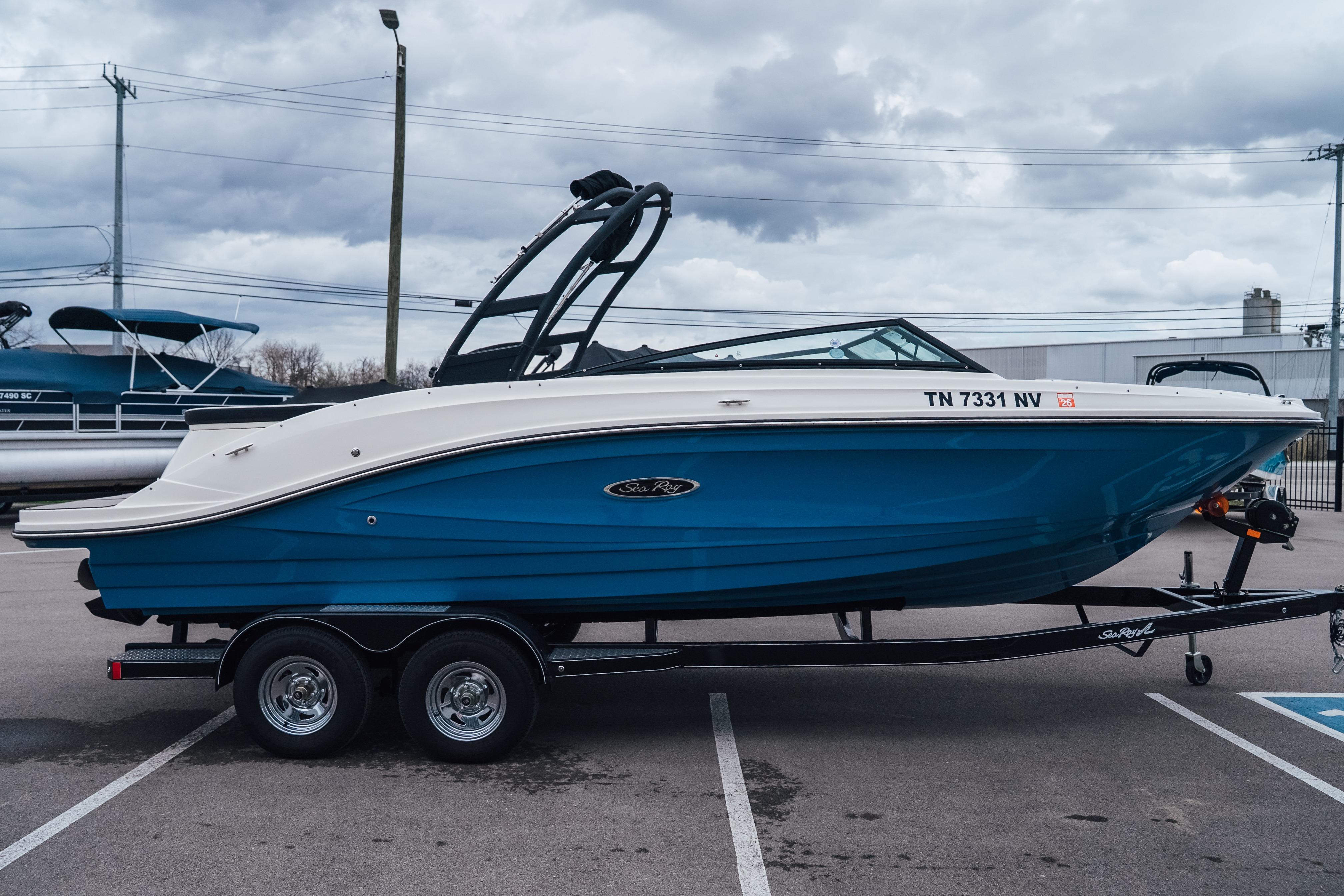 2023 Sea Ray SPX 230 boat on trailer, blue hull, parked outdoors.