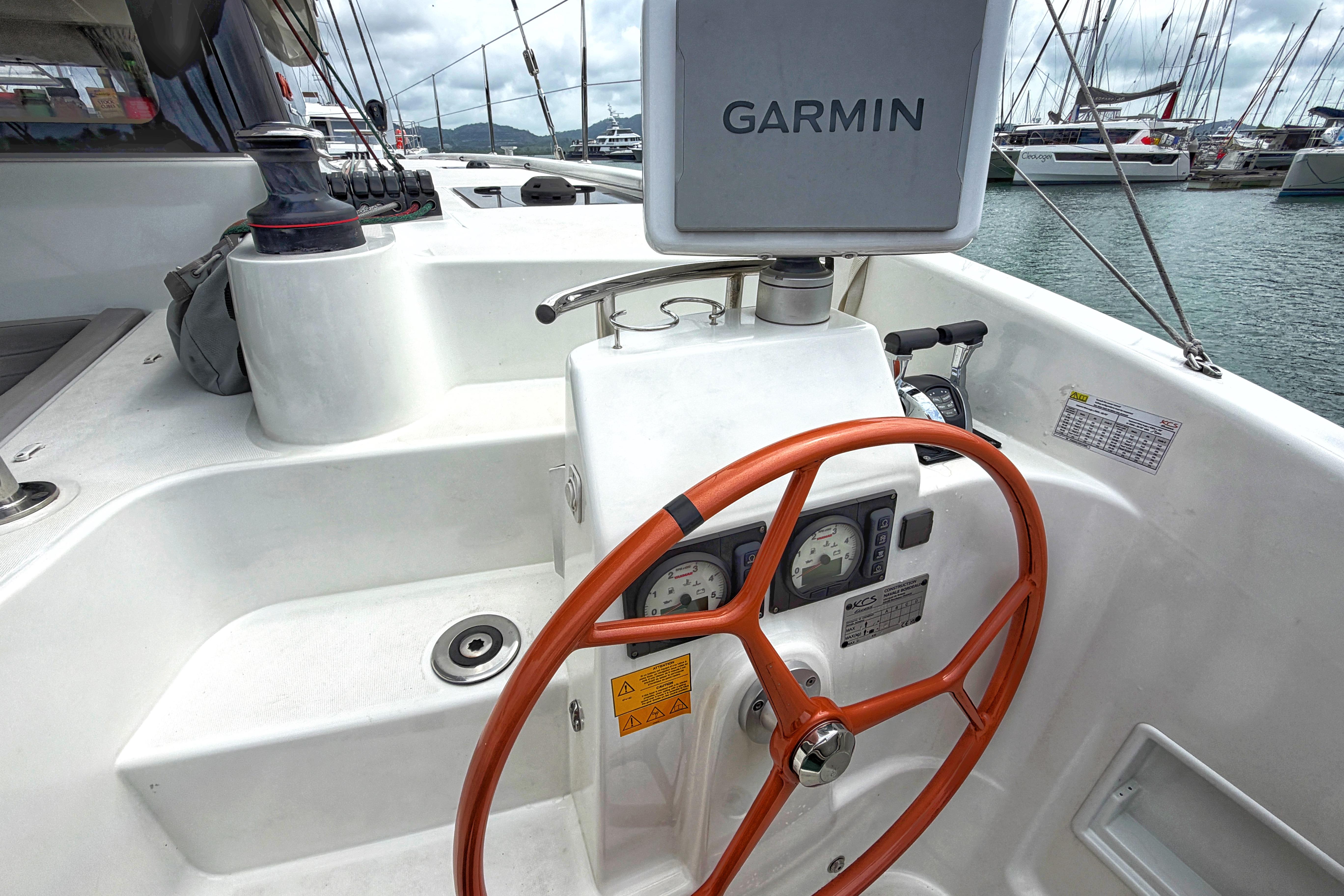 2024 Excess 11 yacht helm with Garmin navigation and orange steering wheel.