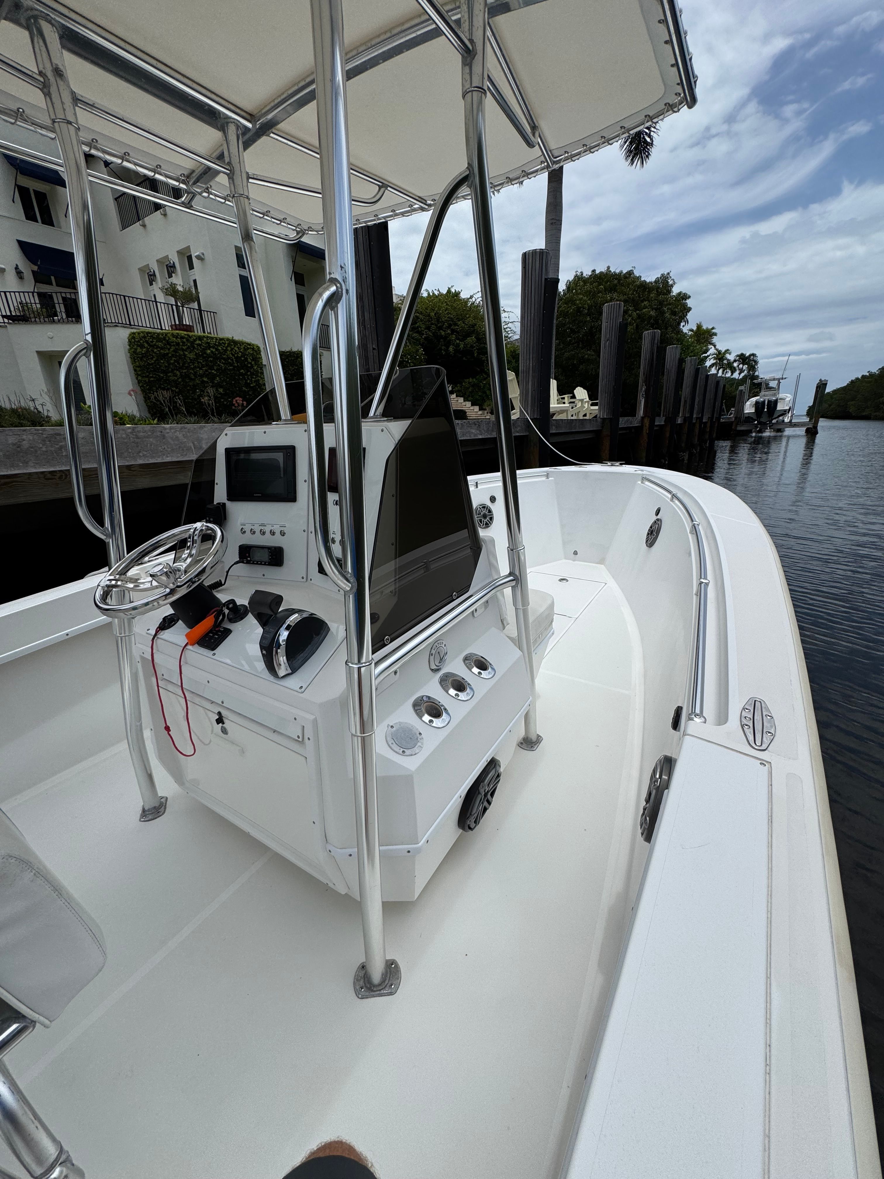 A 2004 Contender 21 boat docked in a calm canal. It features a modern helm console.