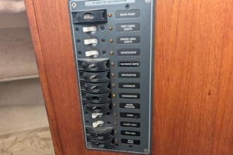 Electrical panel with labeled switches on wooden surface.