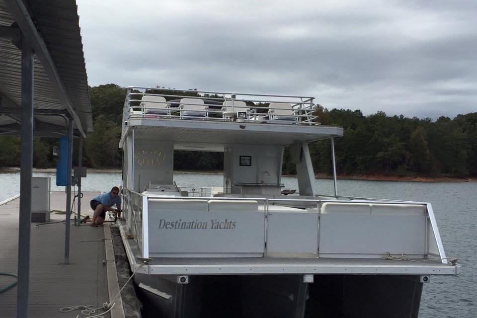 2008 Destination Yachts 45X14 houseboat docked on a lake with trees in the background.