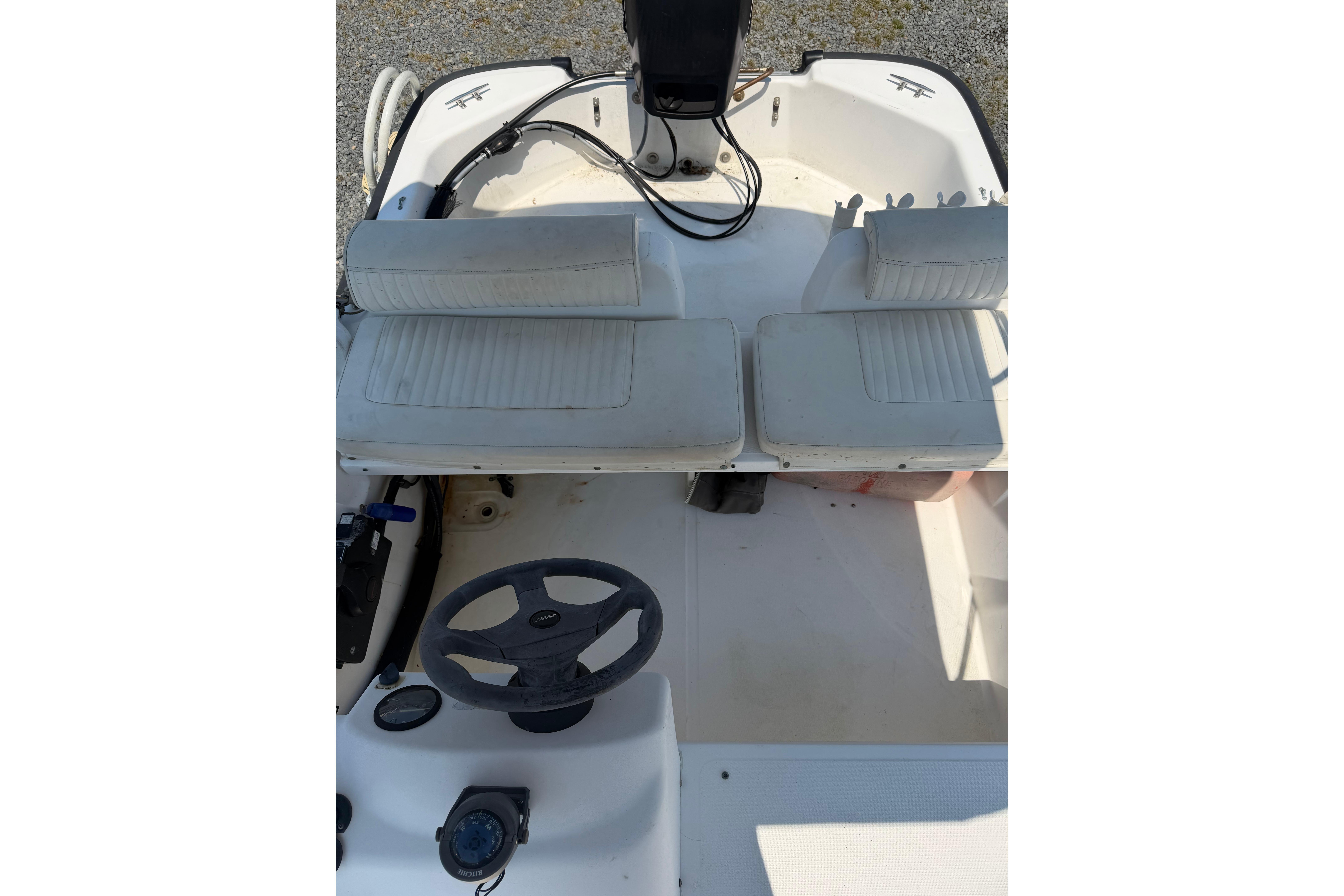 Interior view of a 2003 Boston Whaler 130 Super Sport with two seats and a steering wheel.